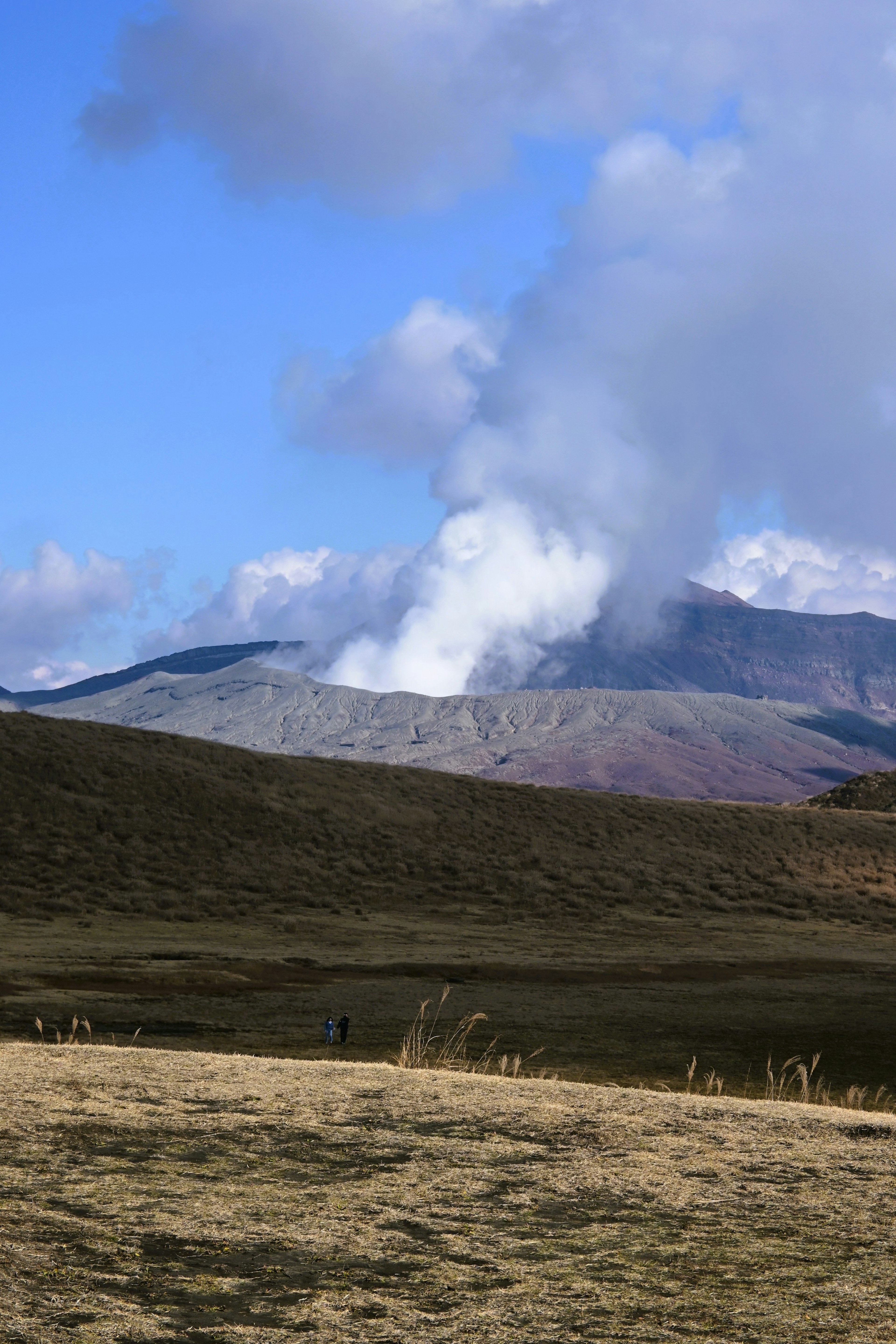 火山からの煙が上がる青空の下の風景