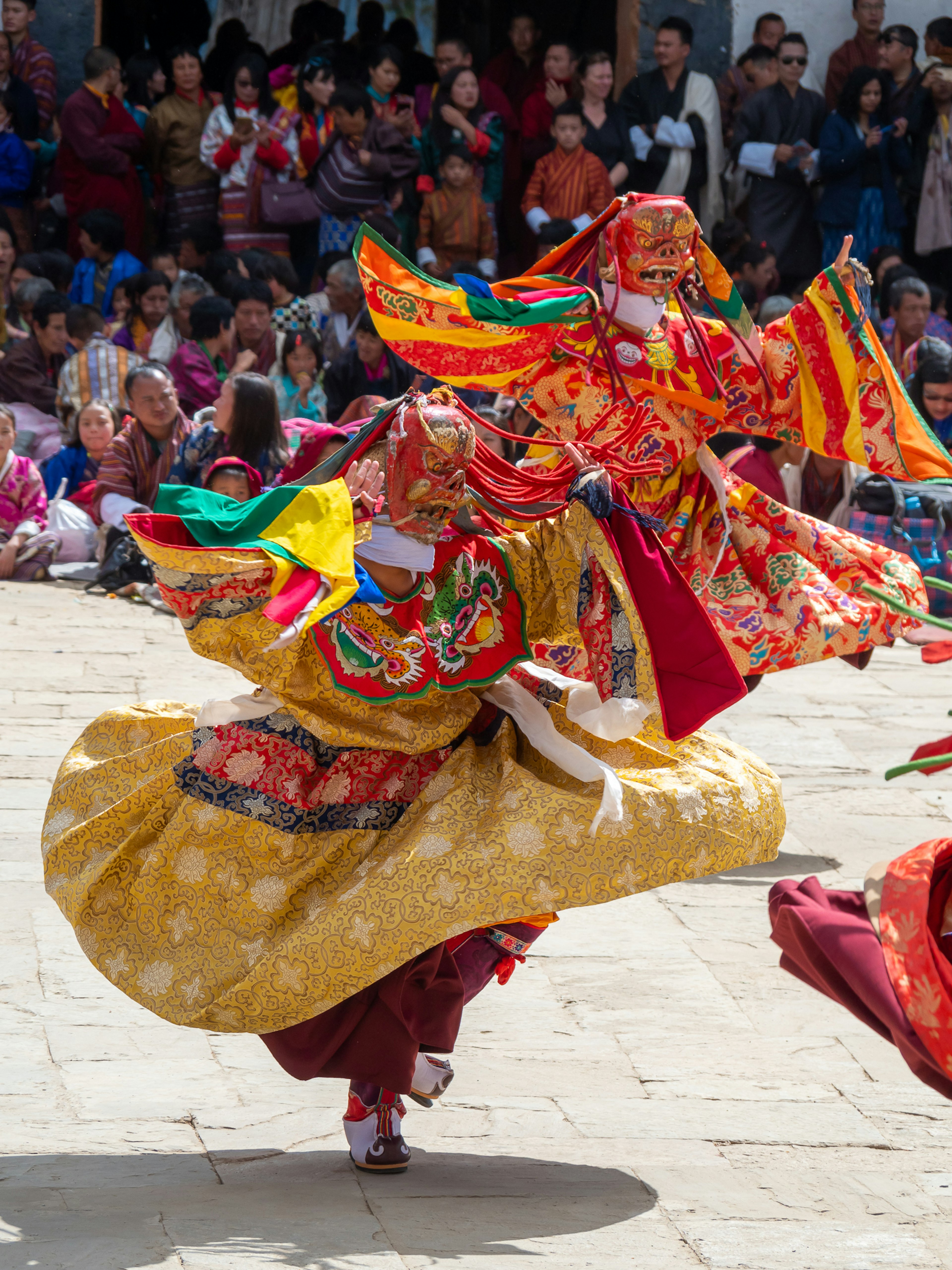 Colorful costumed performers dancing in a traditional festival scene