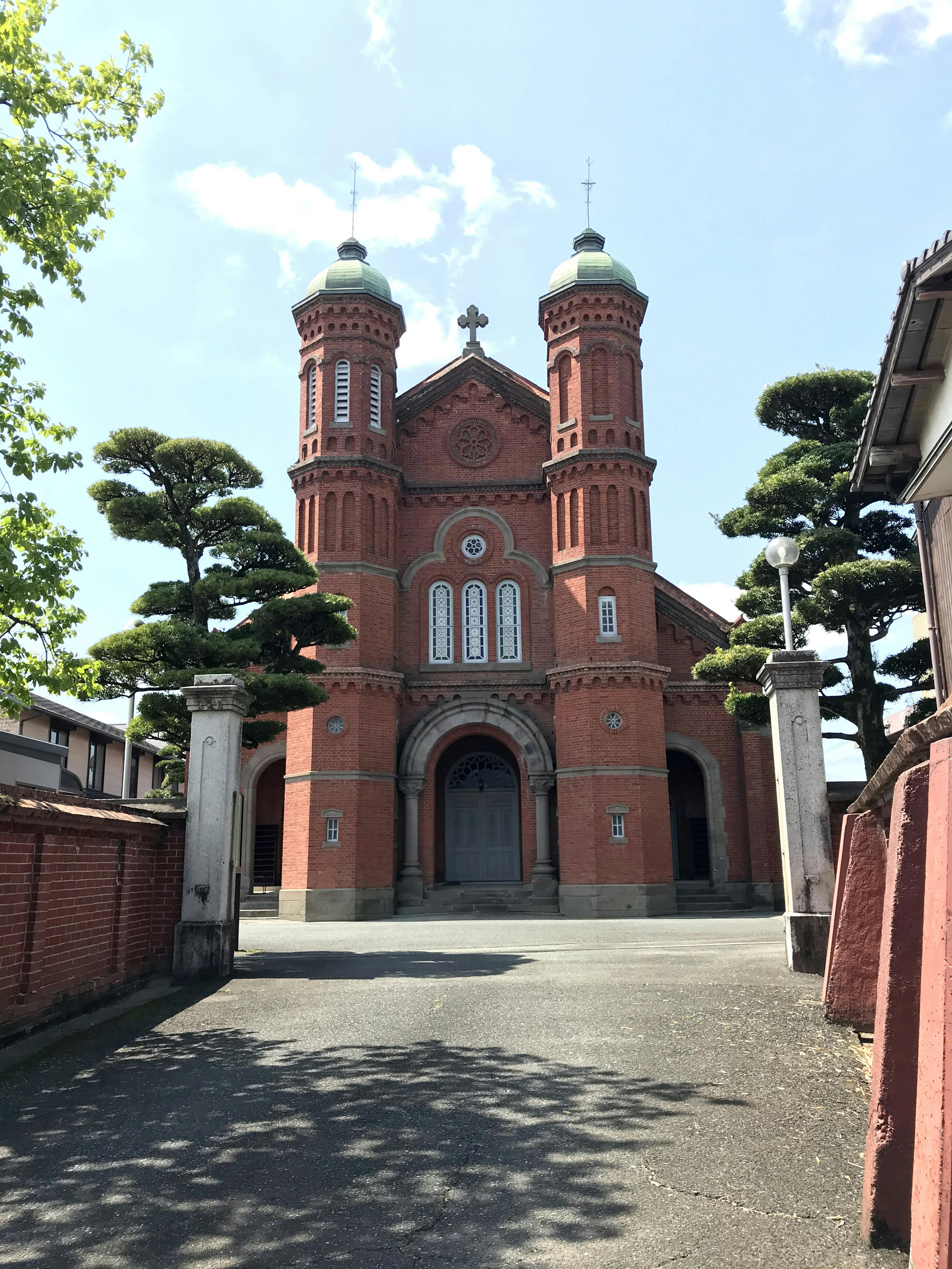 赤レンガの教会と緑の松の木が特徴的な風景