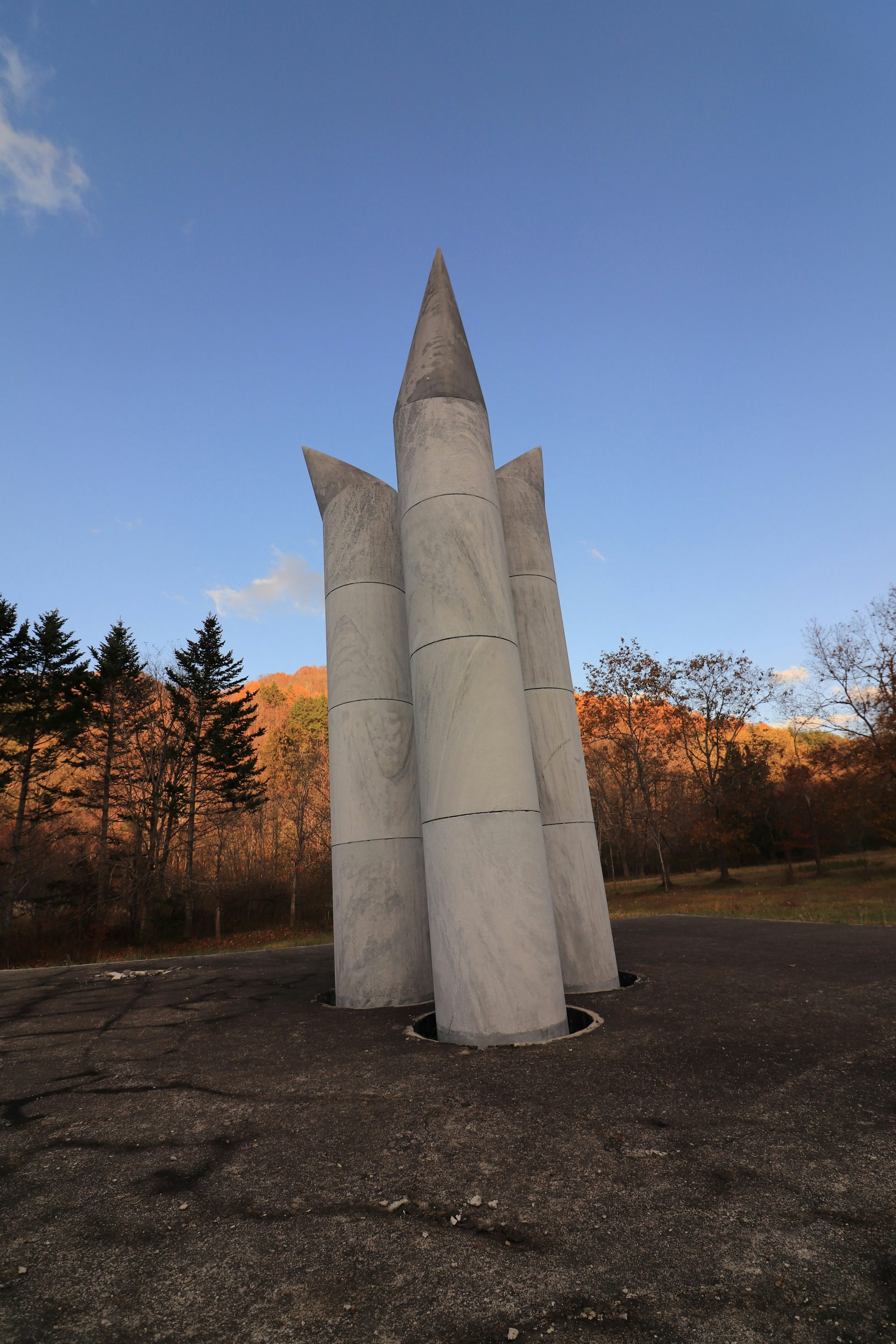 Monumen beton dengan struktur runcing di bawah langit biru