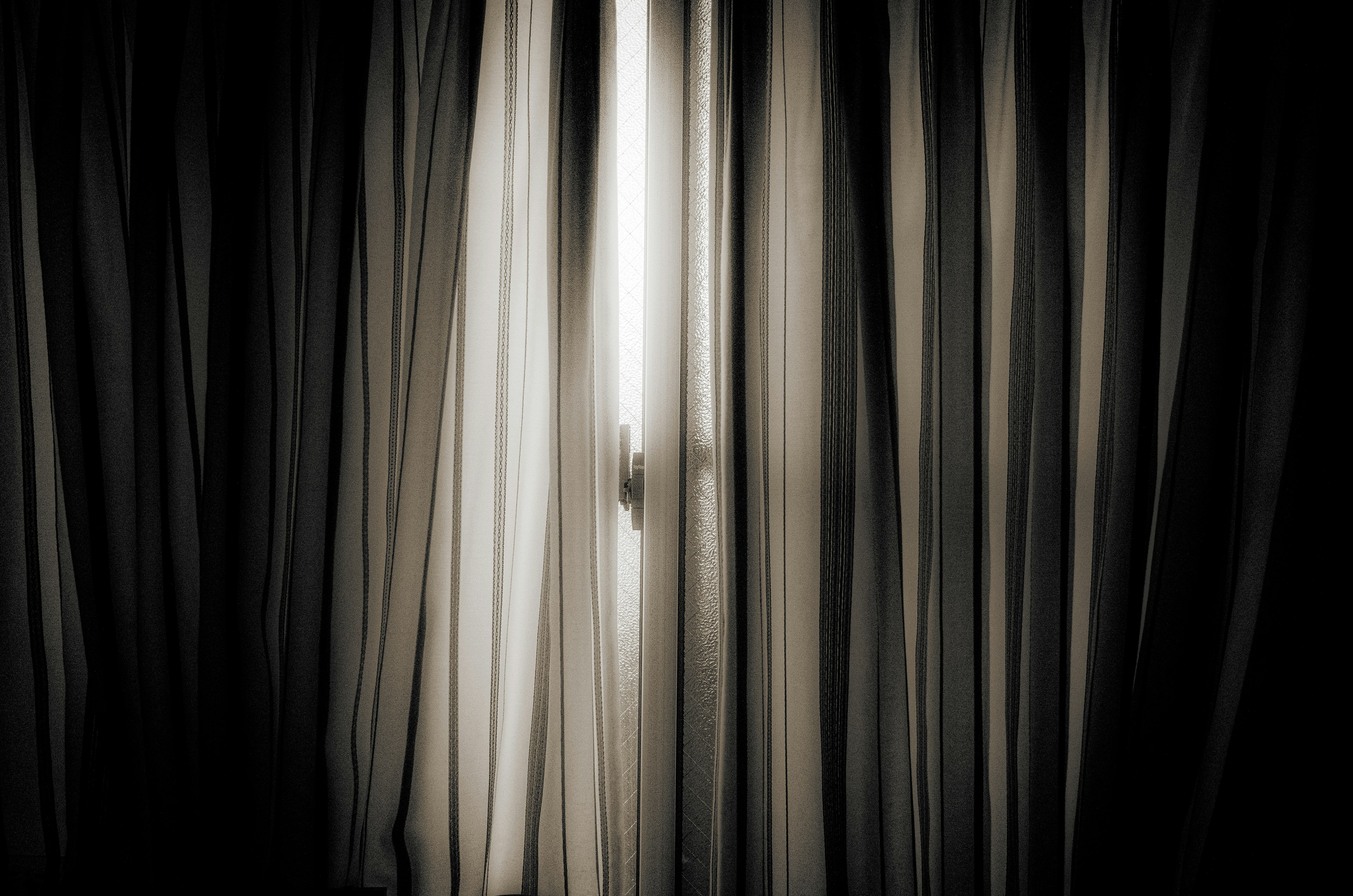 Light silhouette shining through sheer curtains