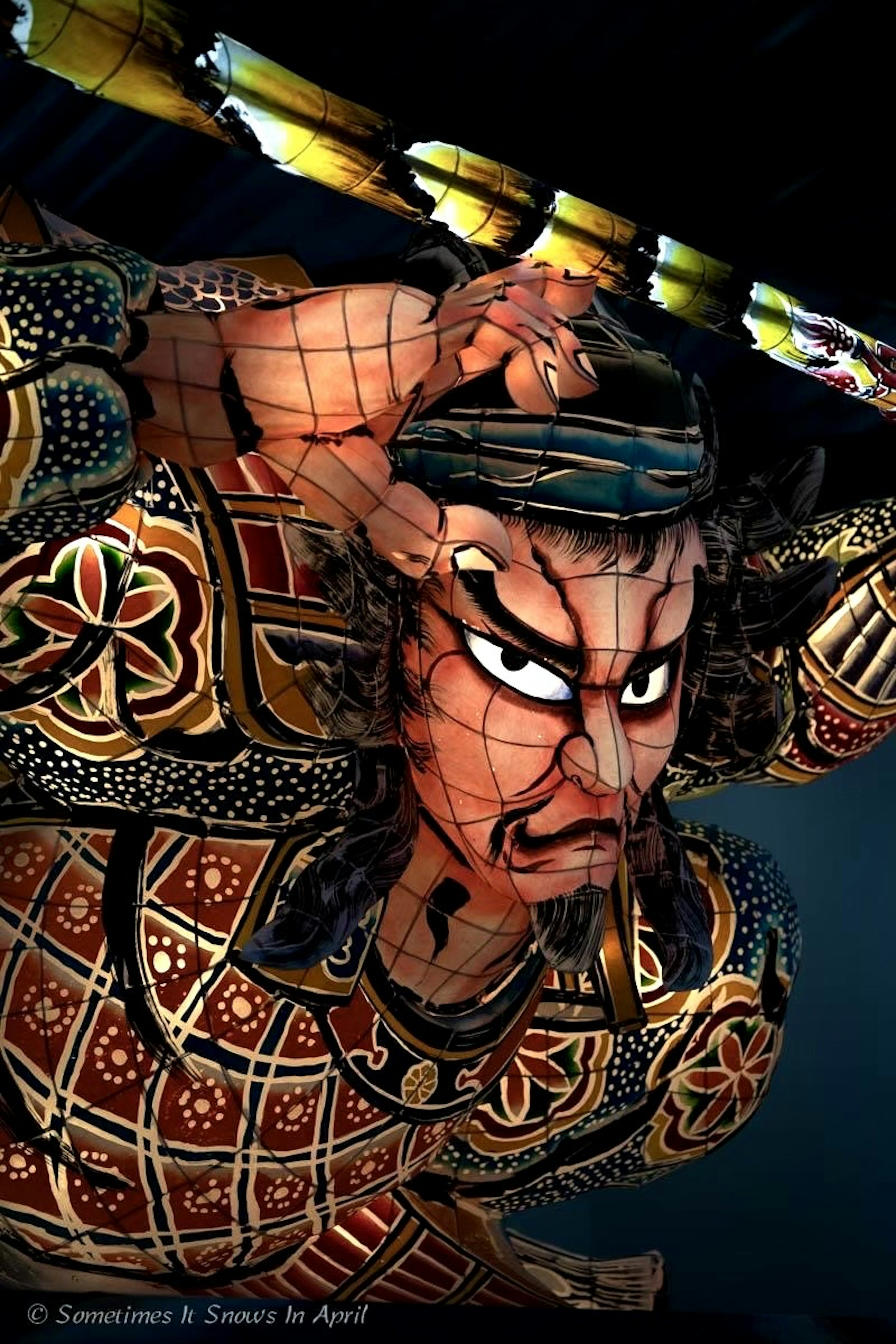 Figure de guerrier japonais traditionnel avec des motifs complexes et une expression faciale dramatique