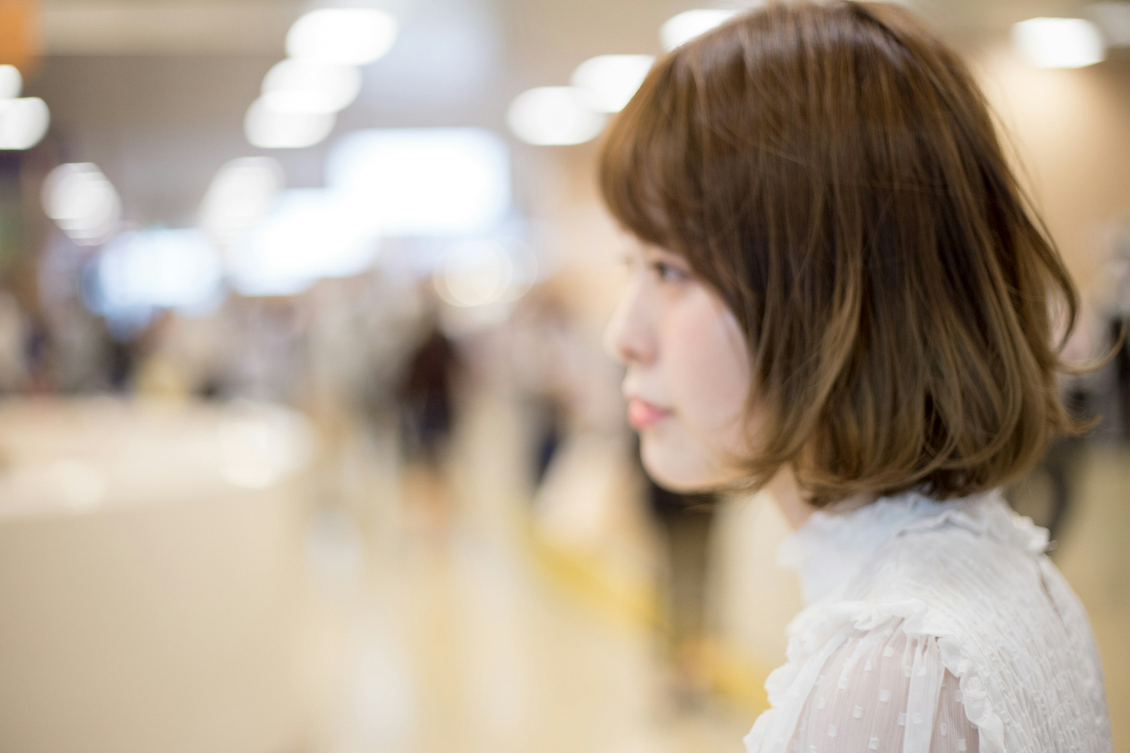 A woman with short hair standing among blurred people in the background