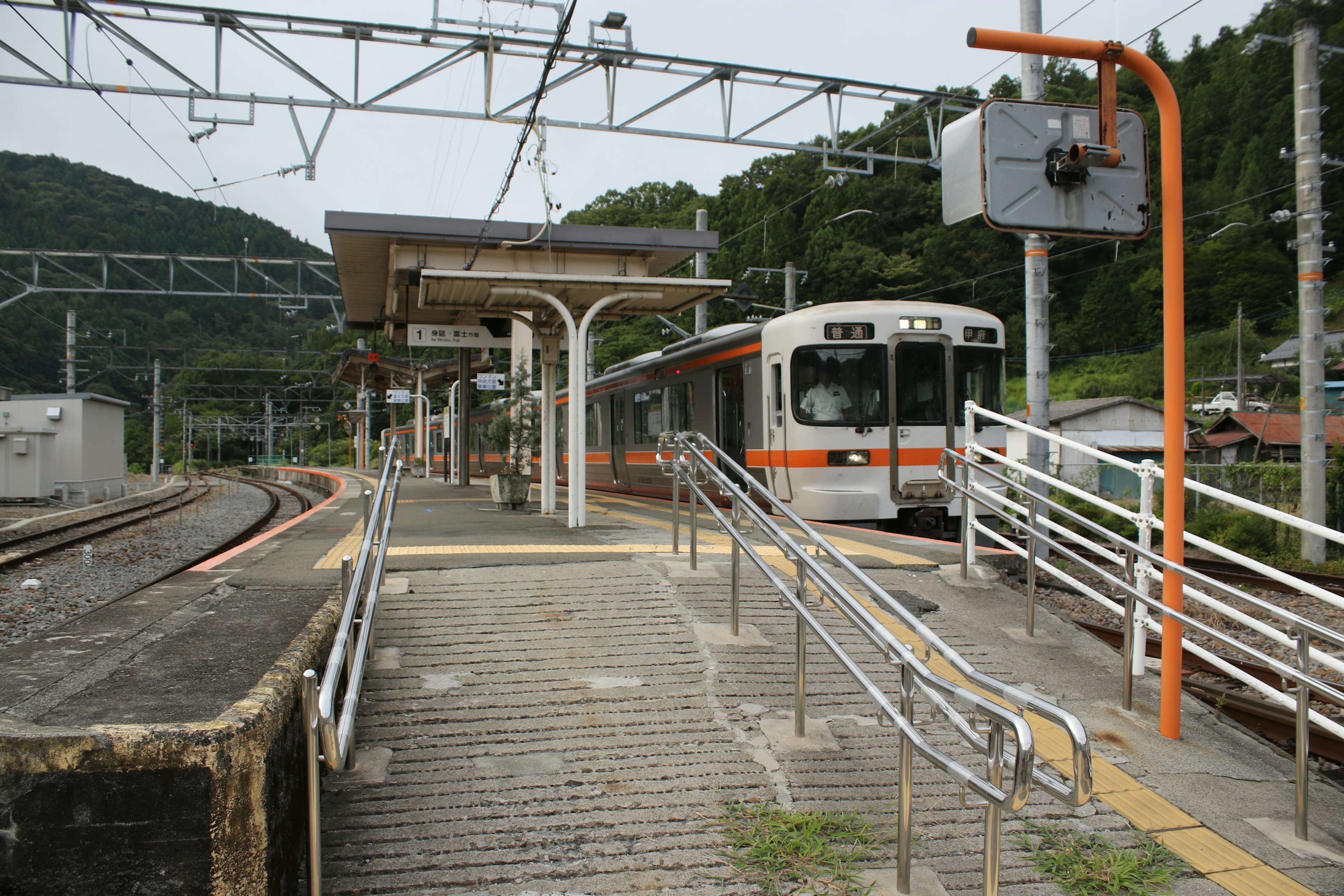 View of a train station platform with an approaching train