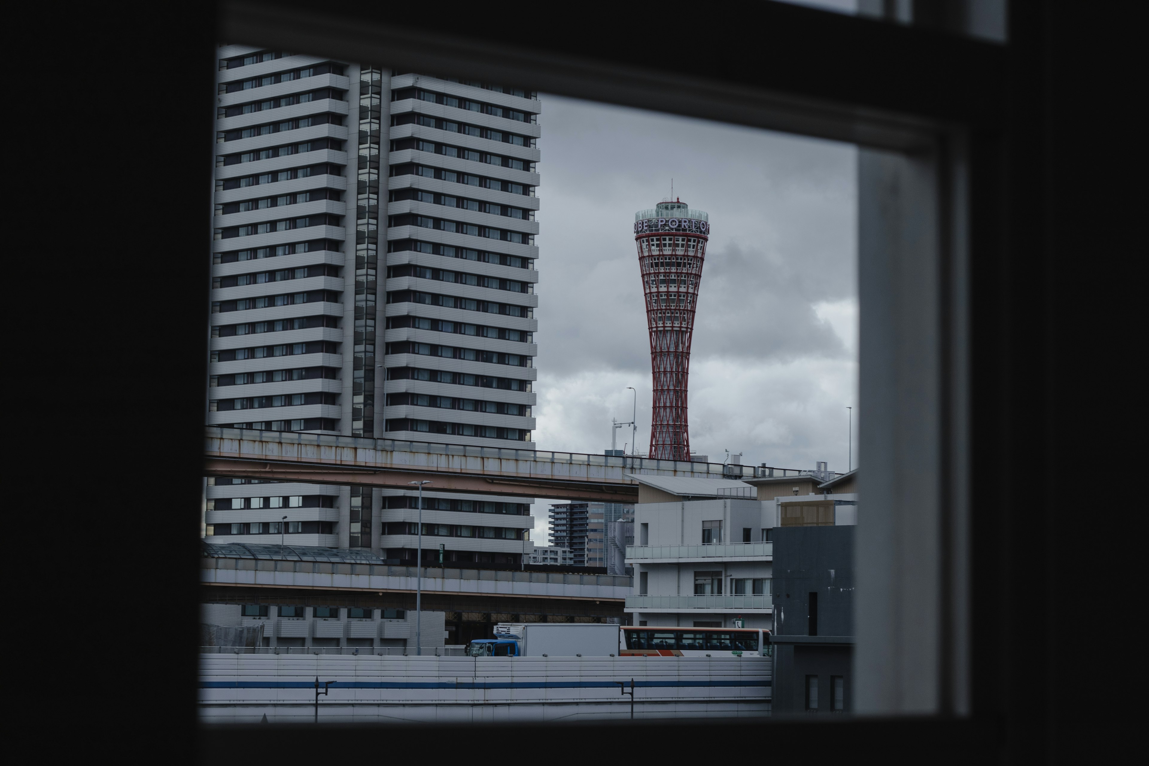 窓から見える神戸ポートタワーと近くの高層ビル