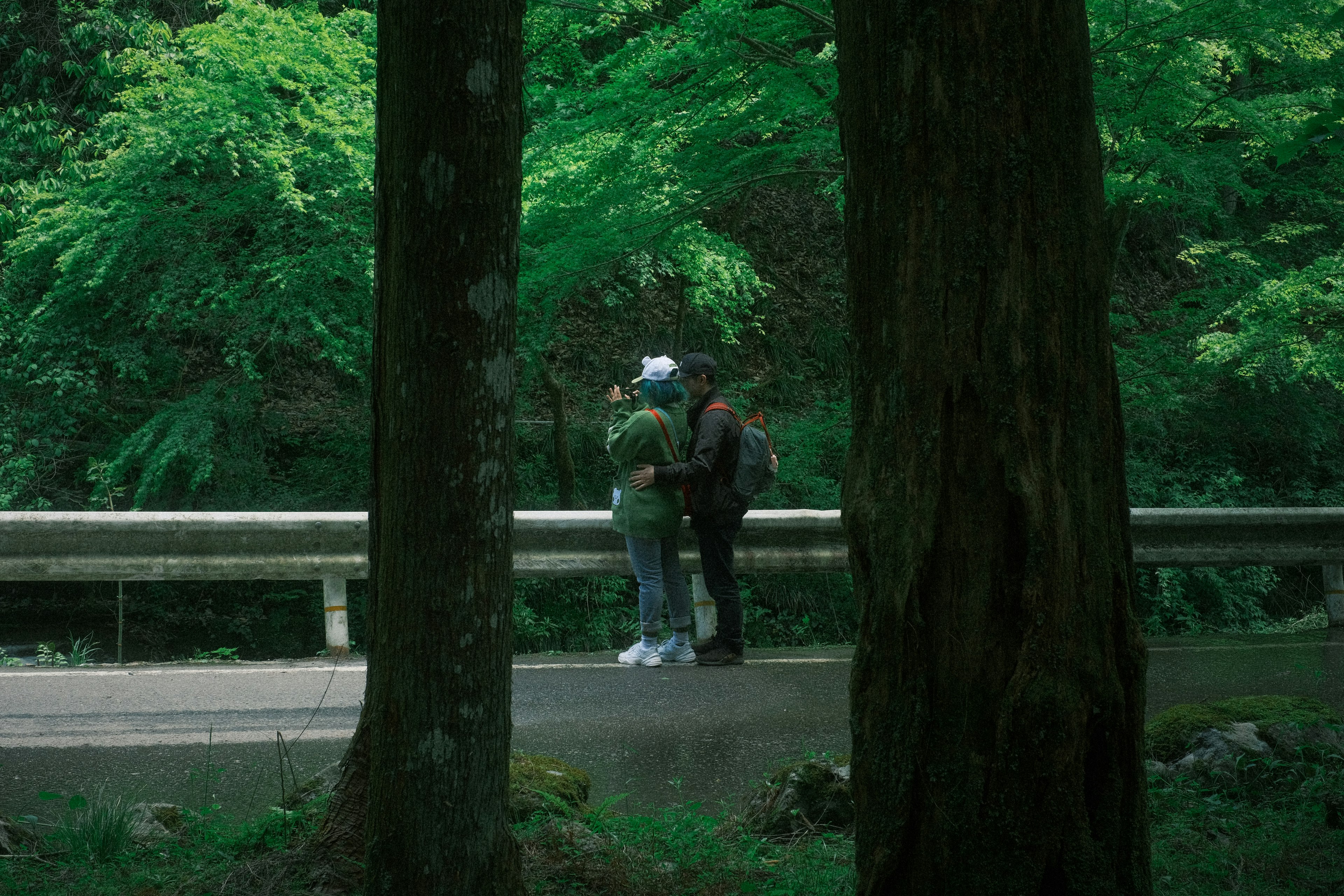 A couple embracing intimately in a lush green forest