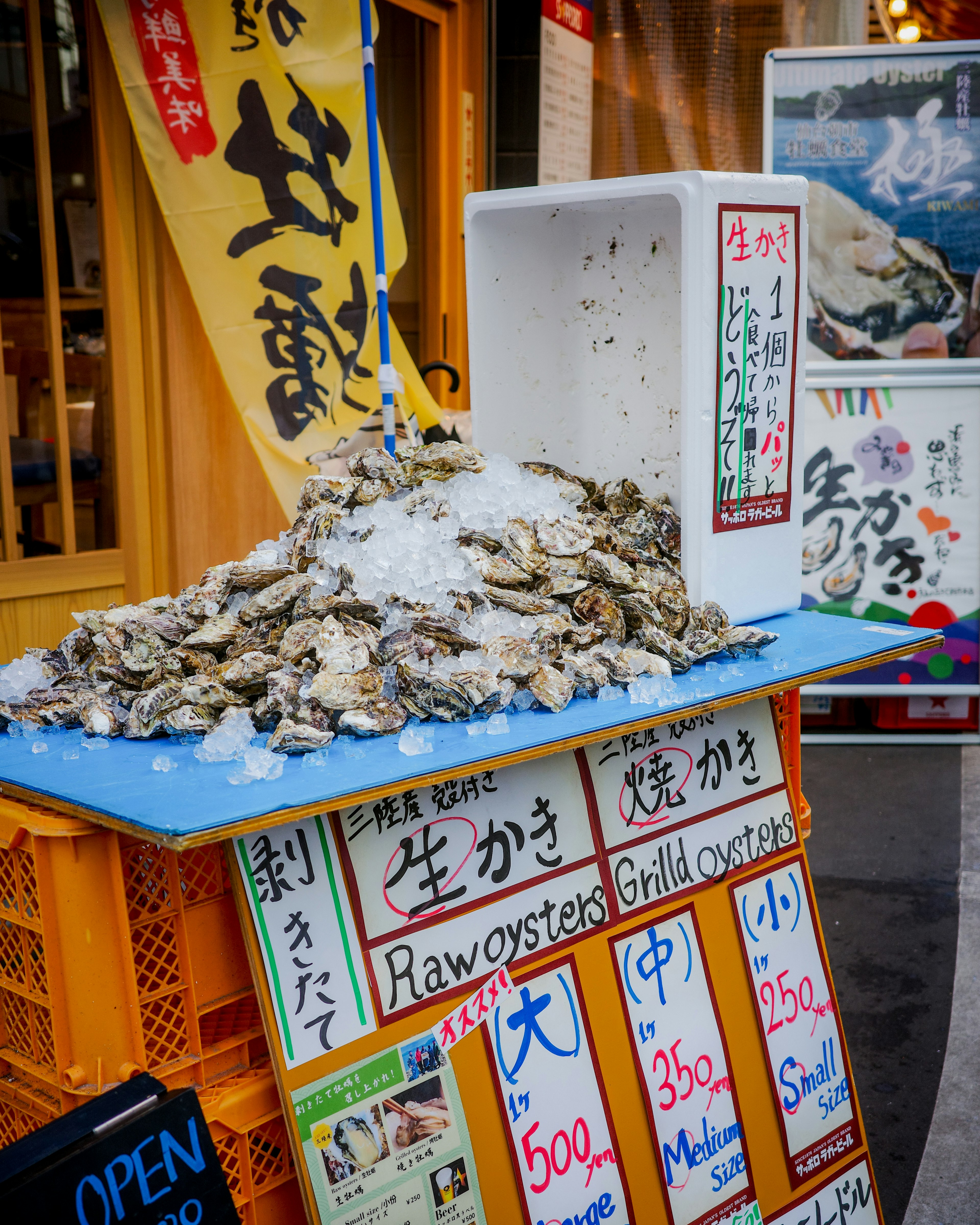 Un chiosco con una montagna di ostriche crude fresche e pannelli del menu