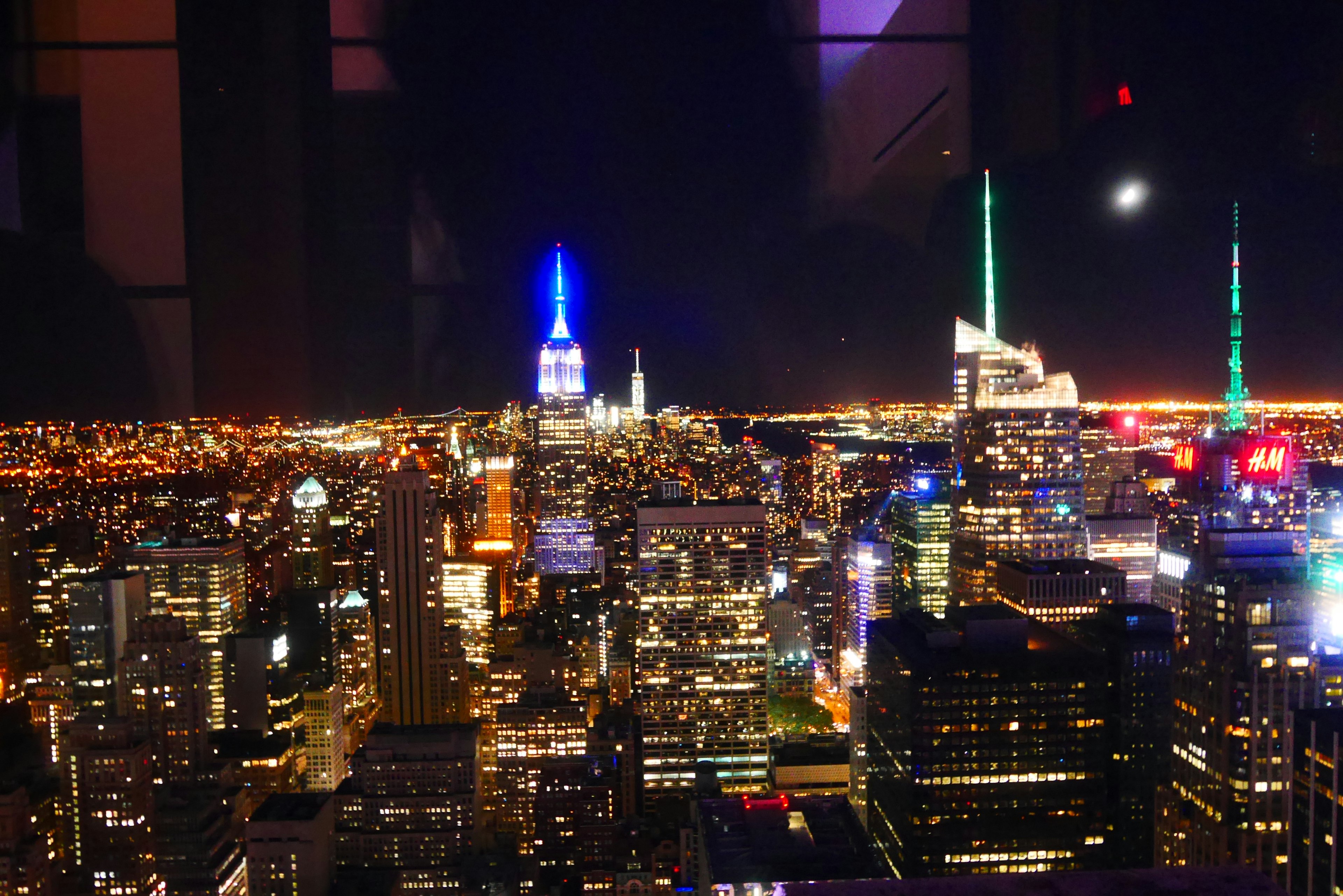 Night view of New York City featuring the Empire State Building with blue lights