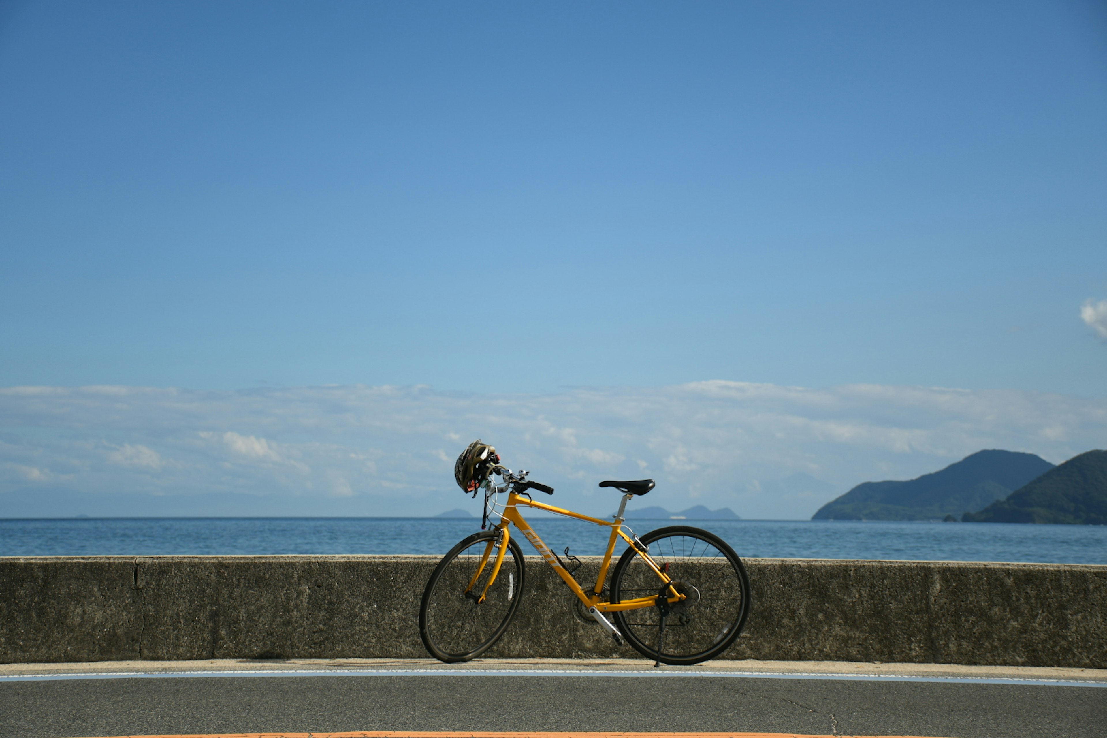 青い海と空の背景に黄色い自転車がある風景