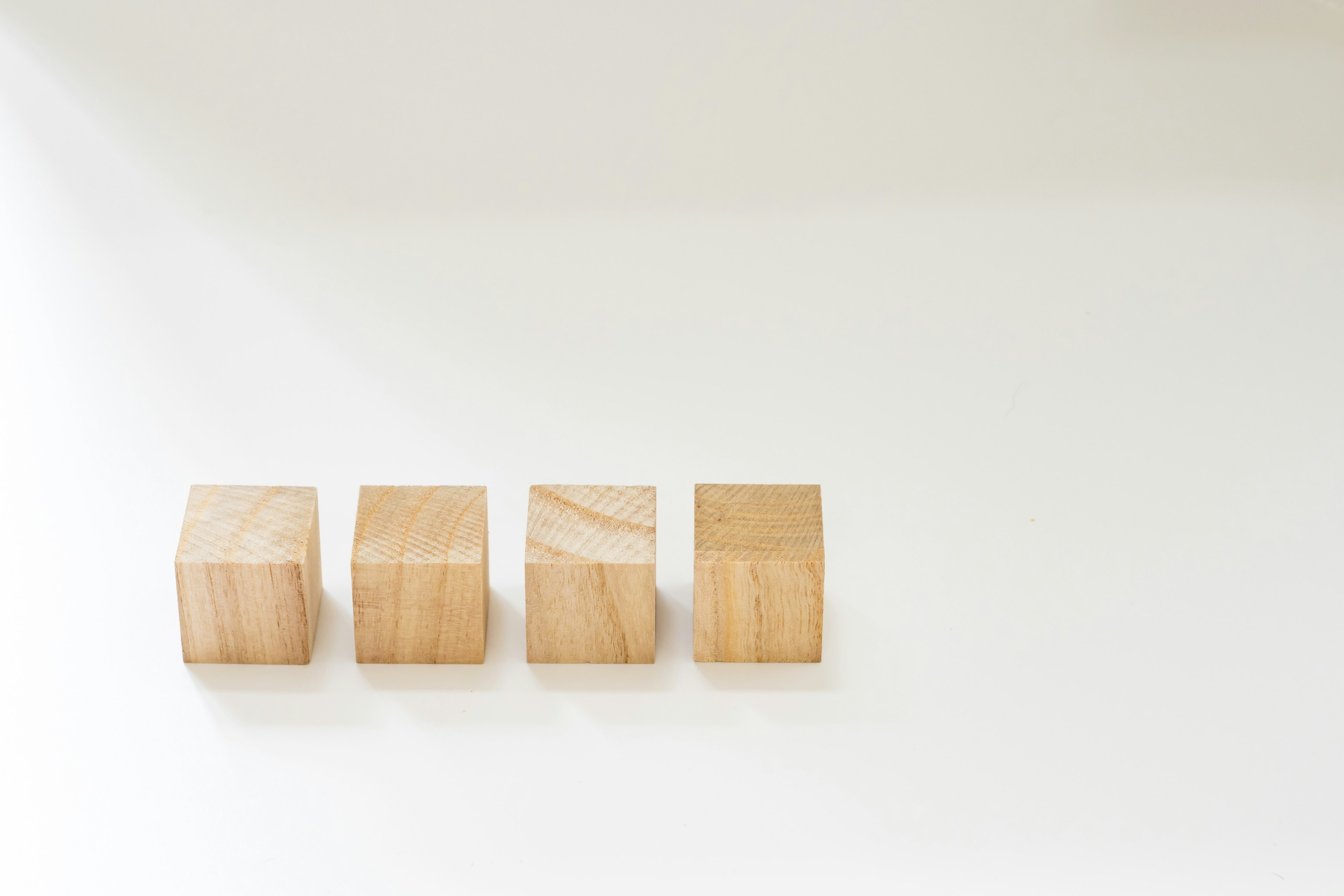 Four wooden blocks arranged on a white background