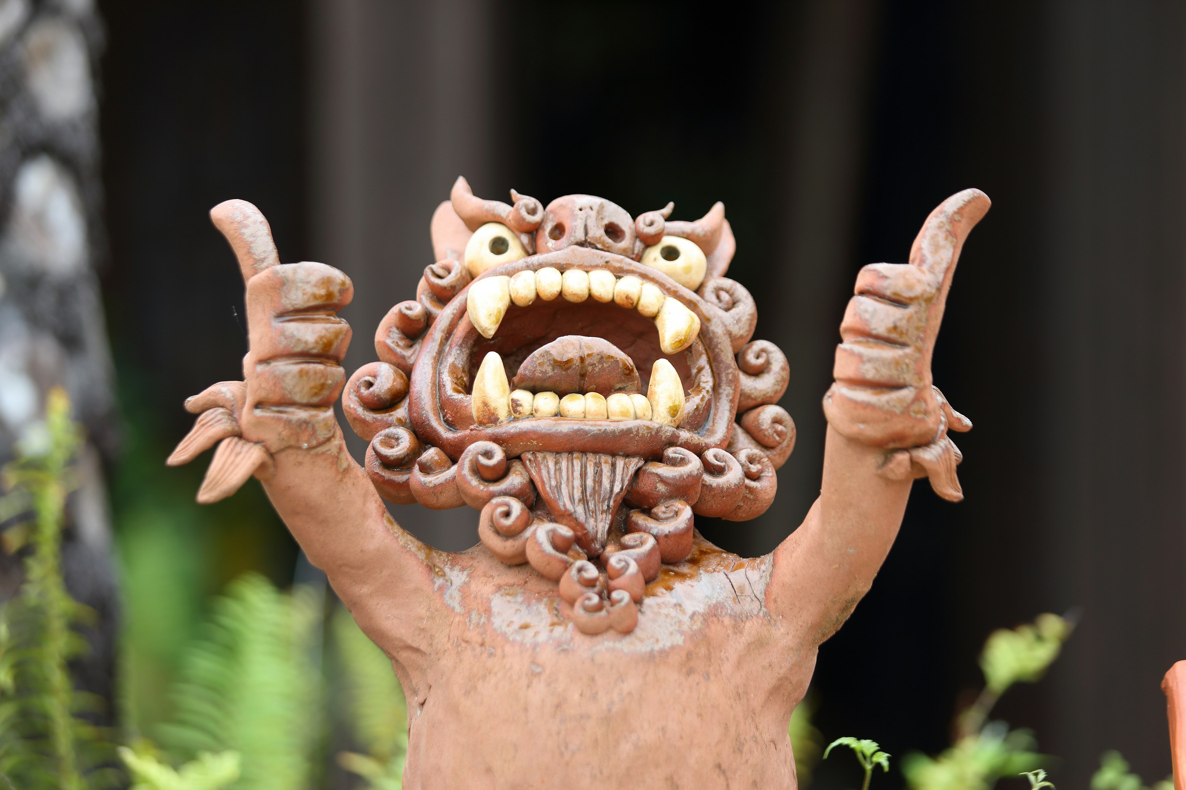 Ceramic lion statue giving a thumbs up