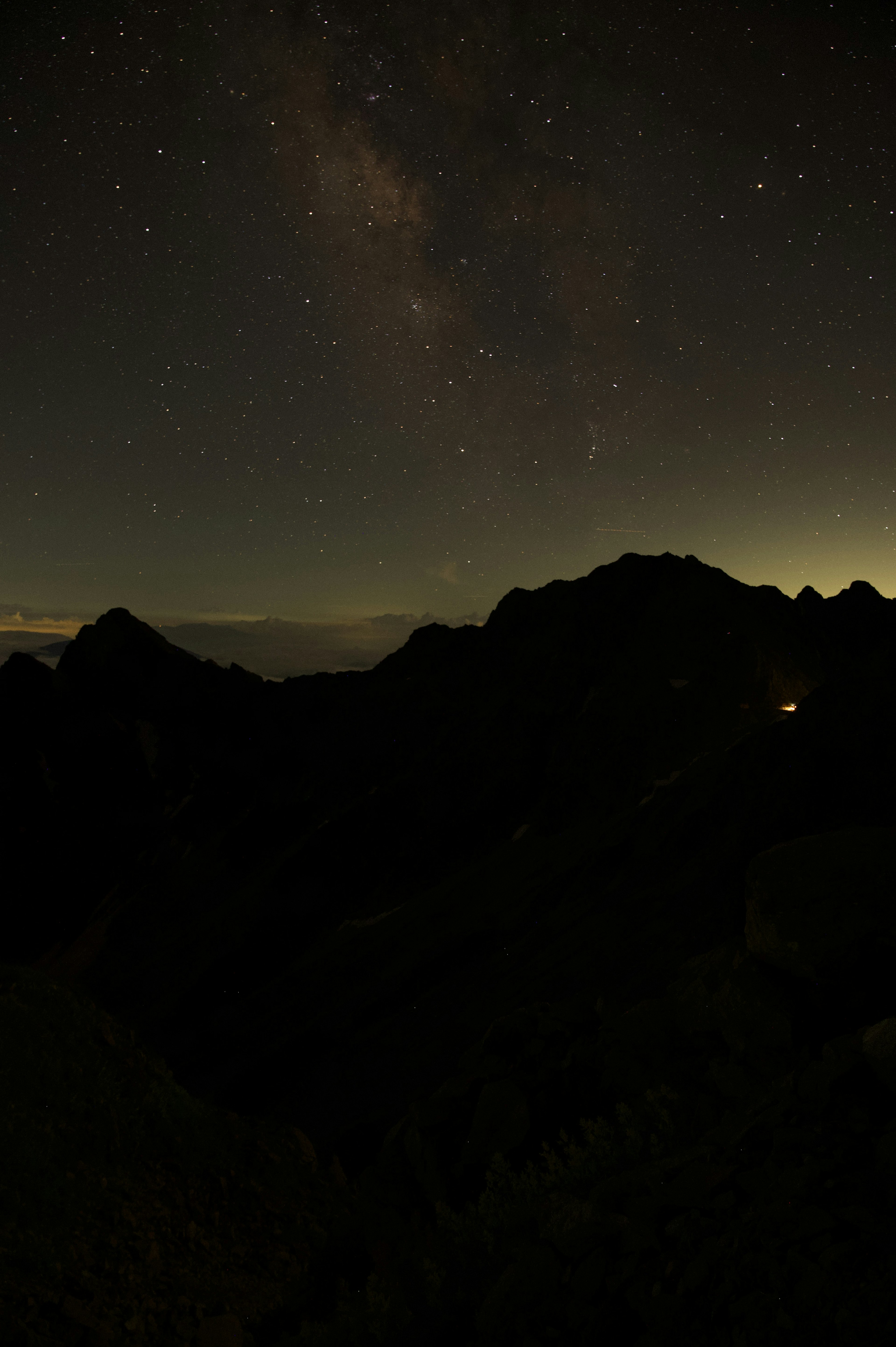 Silhouette di montagne sotto un cielo stellato con la Via Lattea