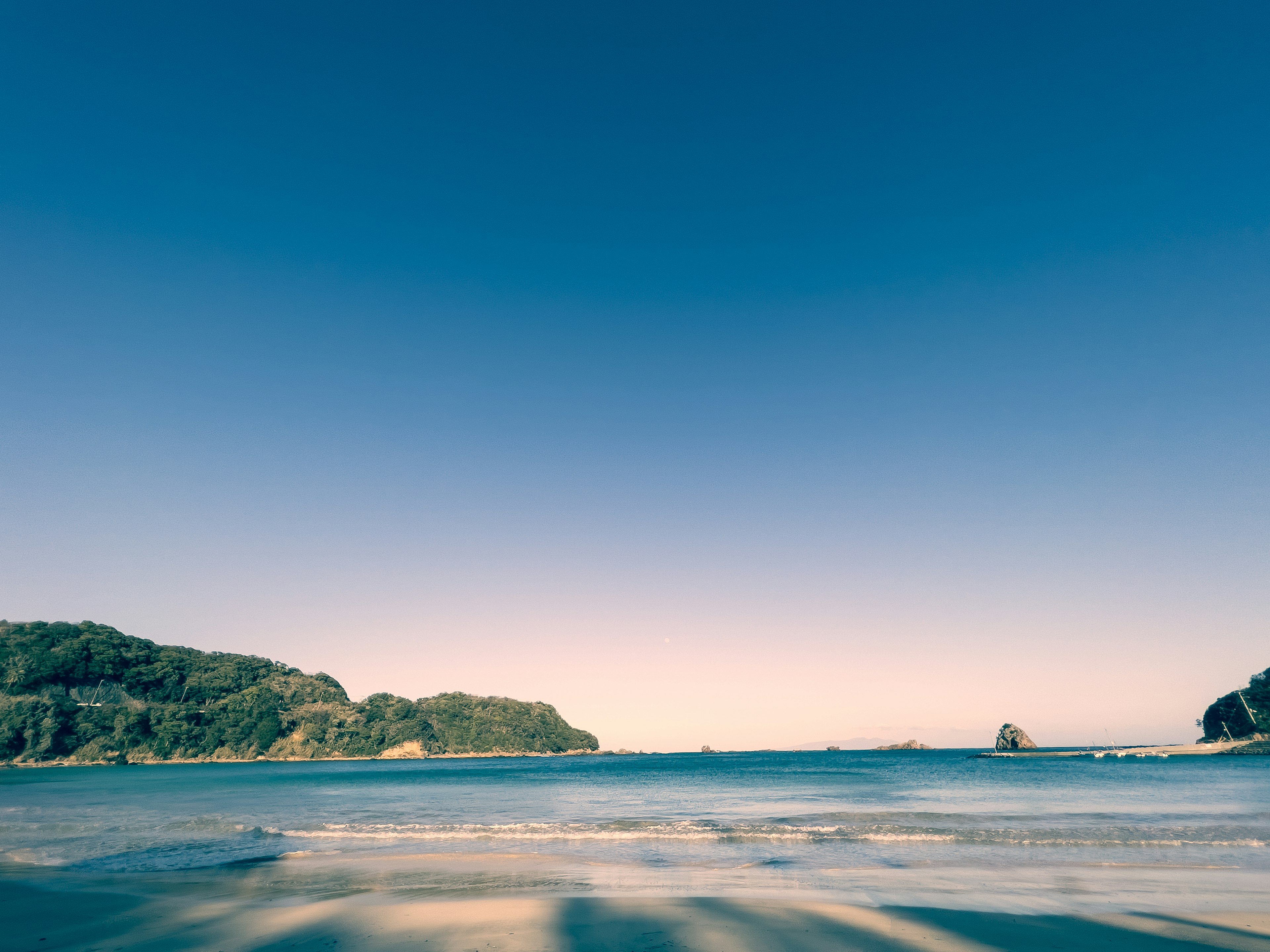 ทิวทัศน์ชายหาดที่มีท้องฟ้าสีฟ้าและทะเลสงบ