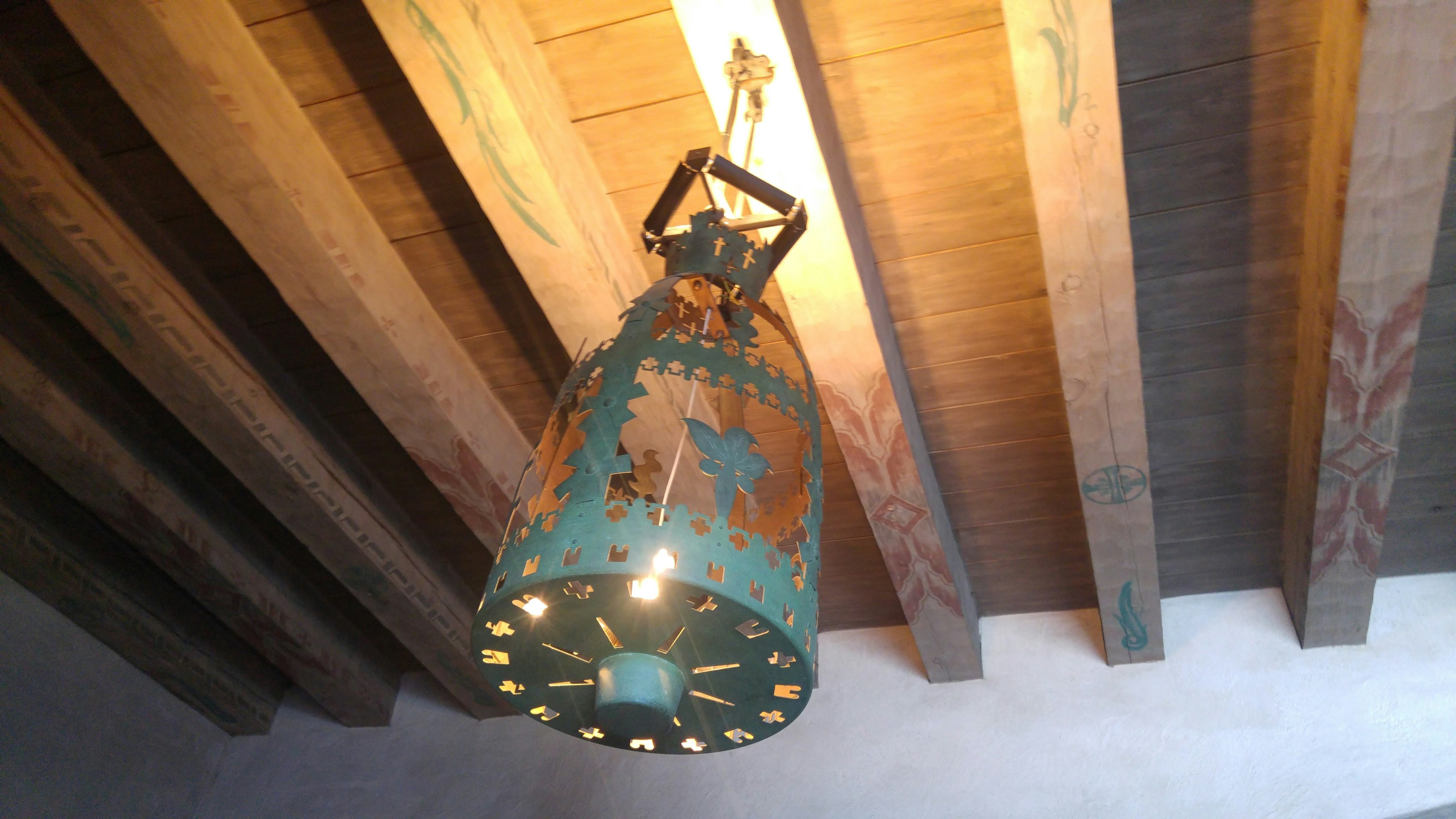 Lampe vintage teal suspendue avec un design complexe et des poutres en bois