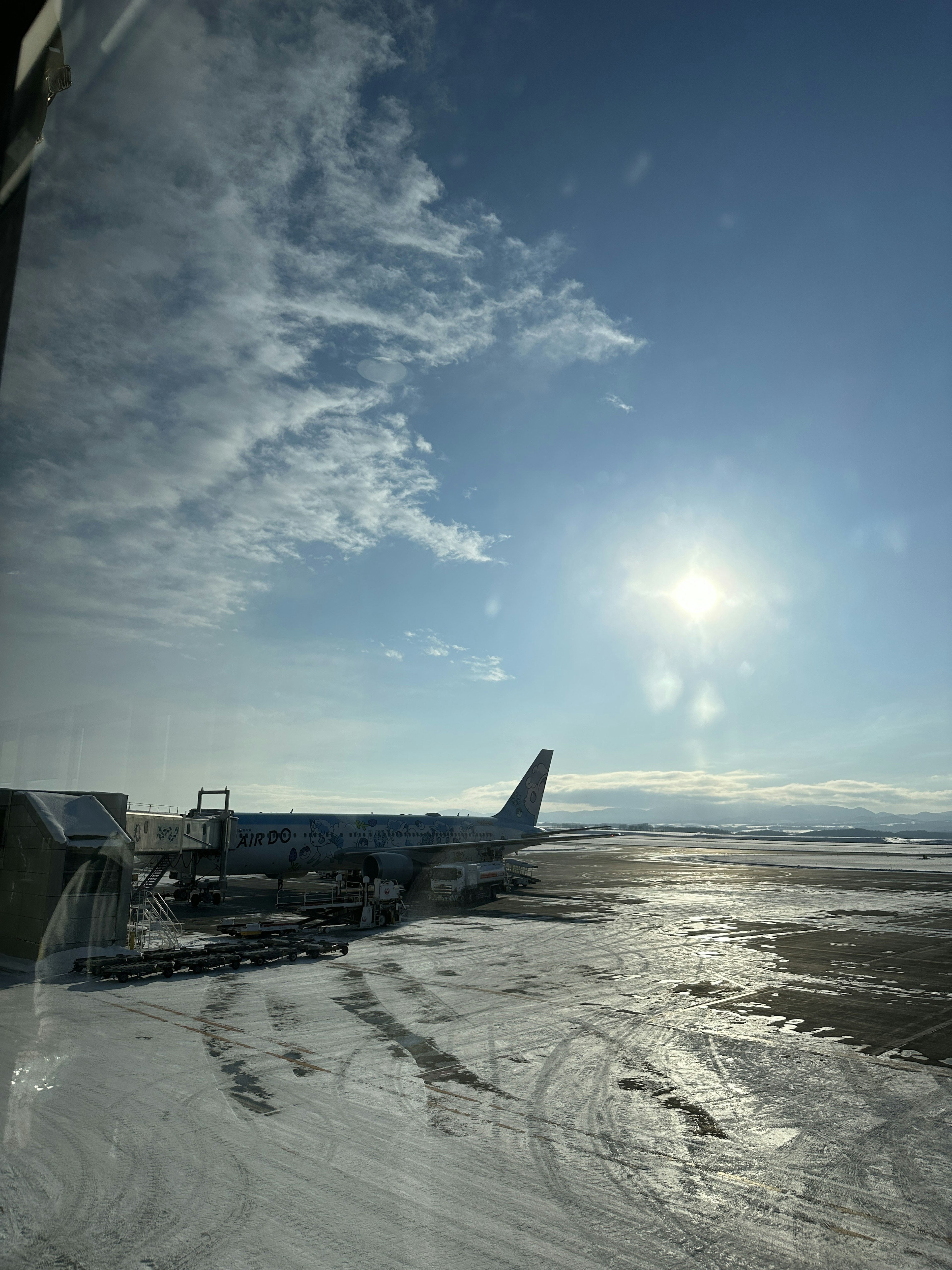 Sonniger Tag am Flughafen mit schneebedeckter Landebahn und einem Flugzeug