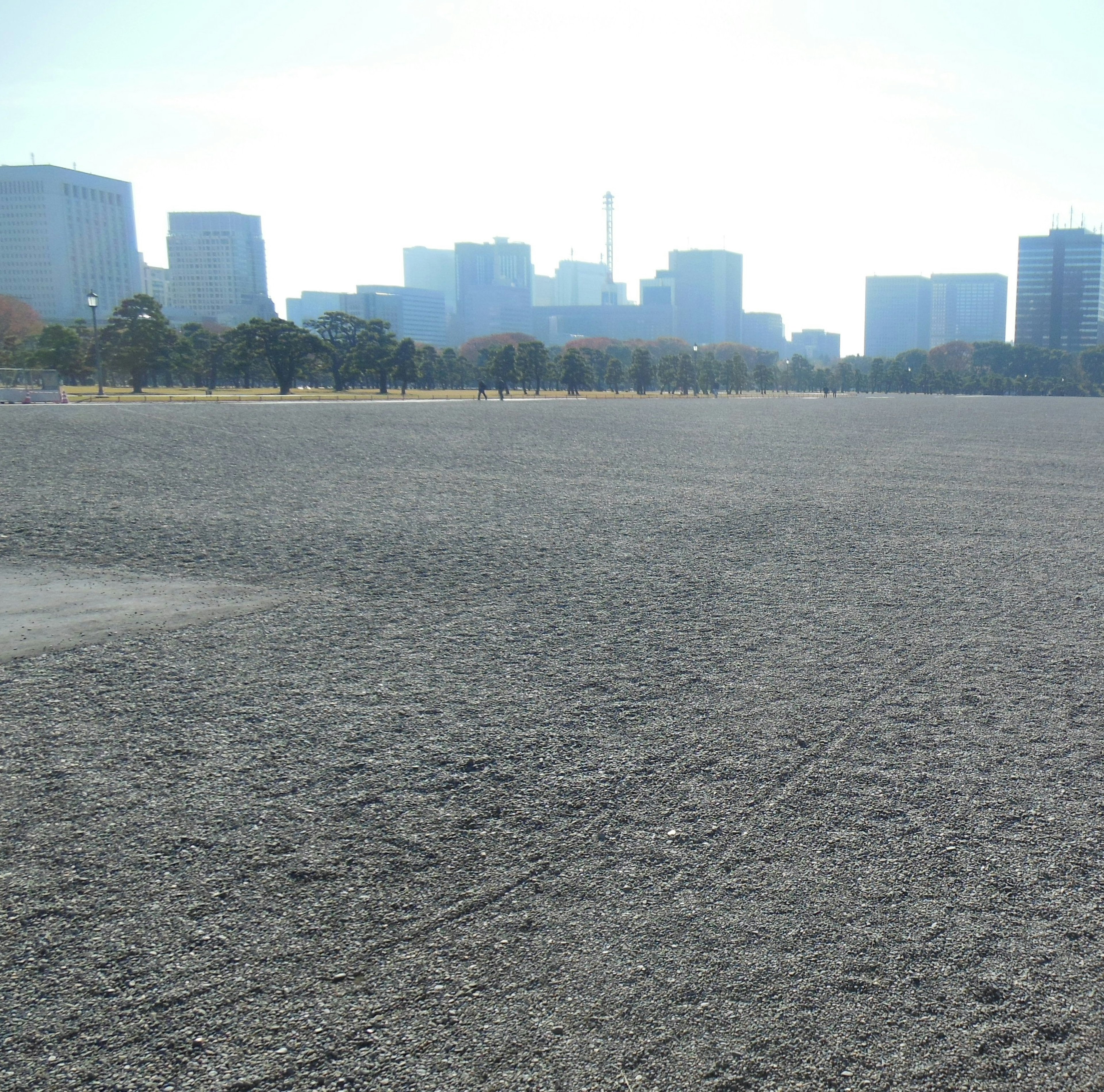 Wide gravel space with skyscrapers in the background