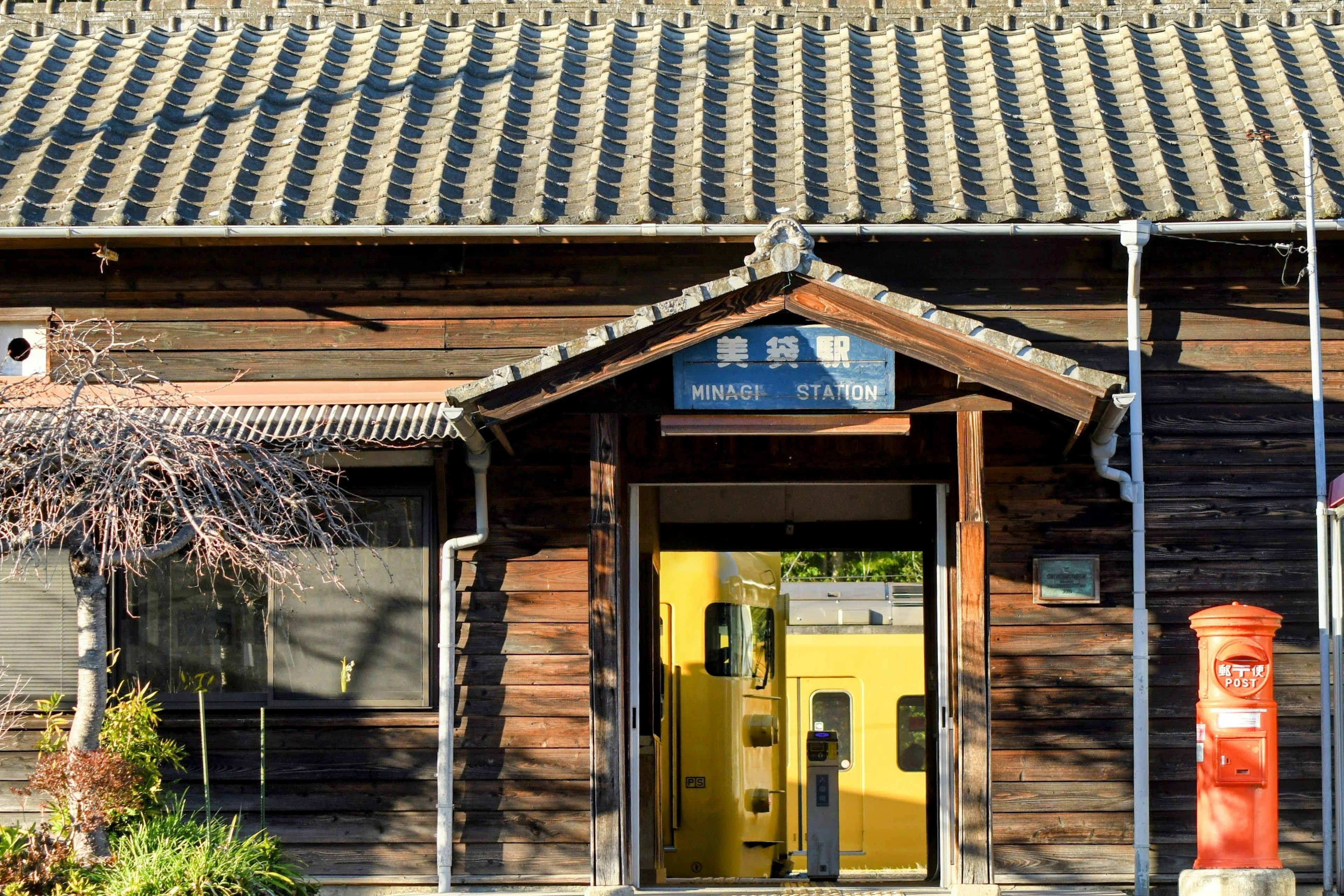 Entrance of a wooden train station with a yellow train door visible