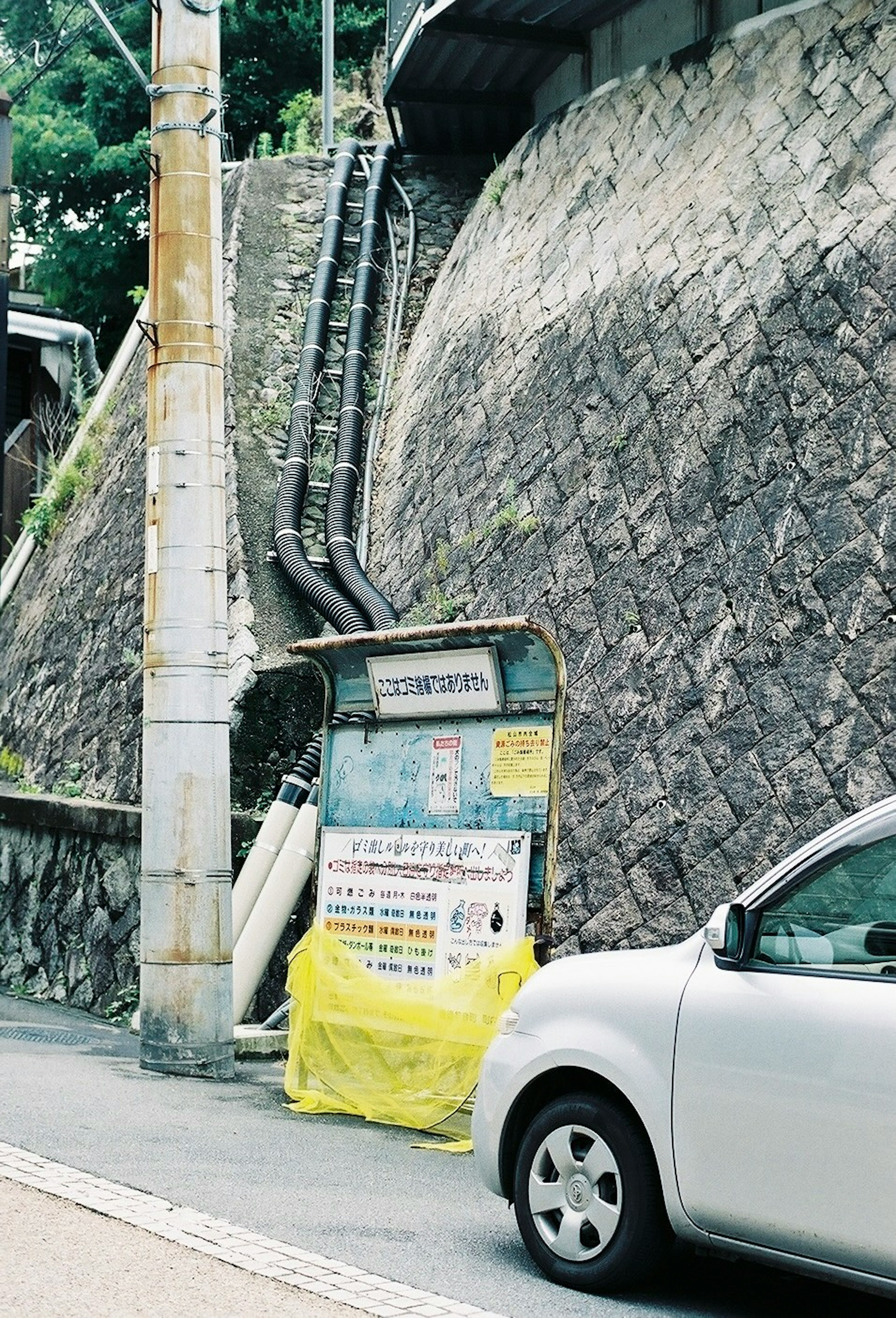 Escena de carretera con una pared rocosa y un cartel cubierto de amarillo