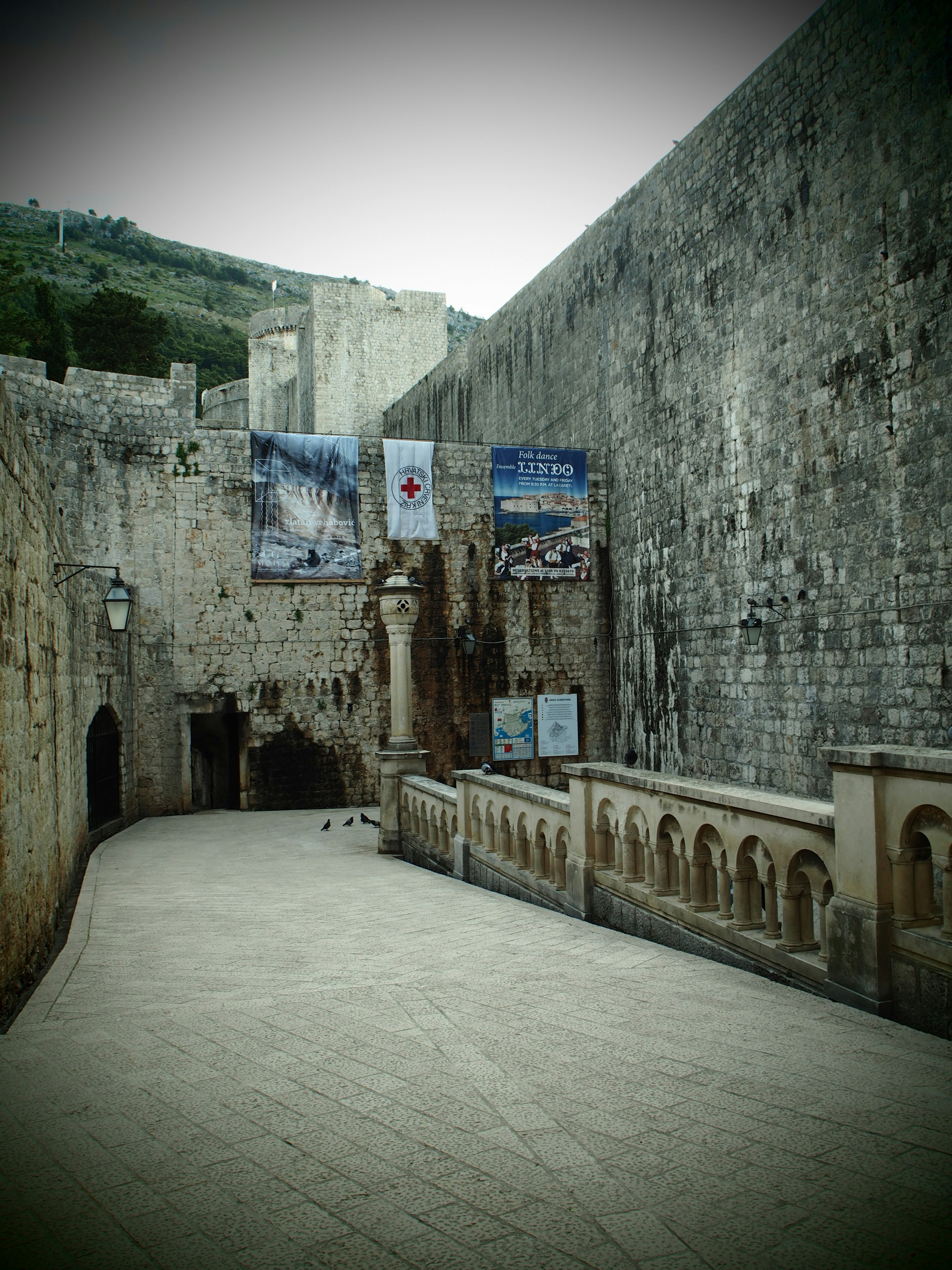 Strada tranquilla con vecchie mura in pietra e striscioni decorativi