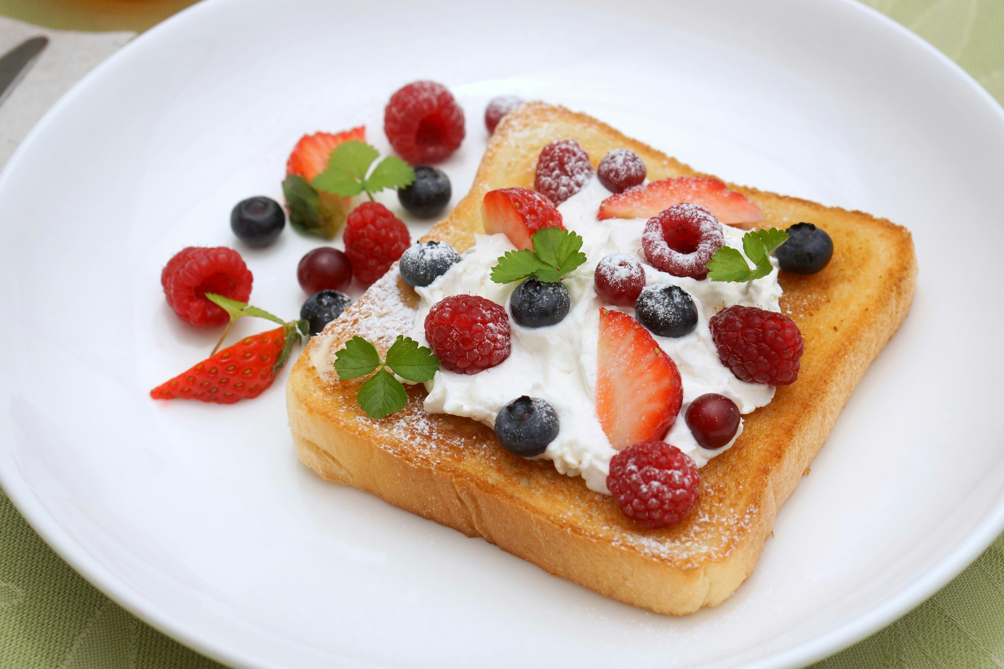 Sweet toast topped with cream and mixed berries