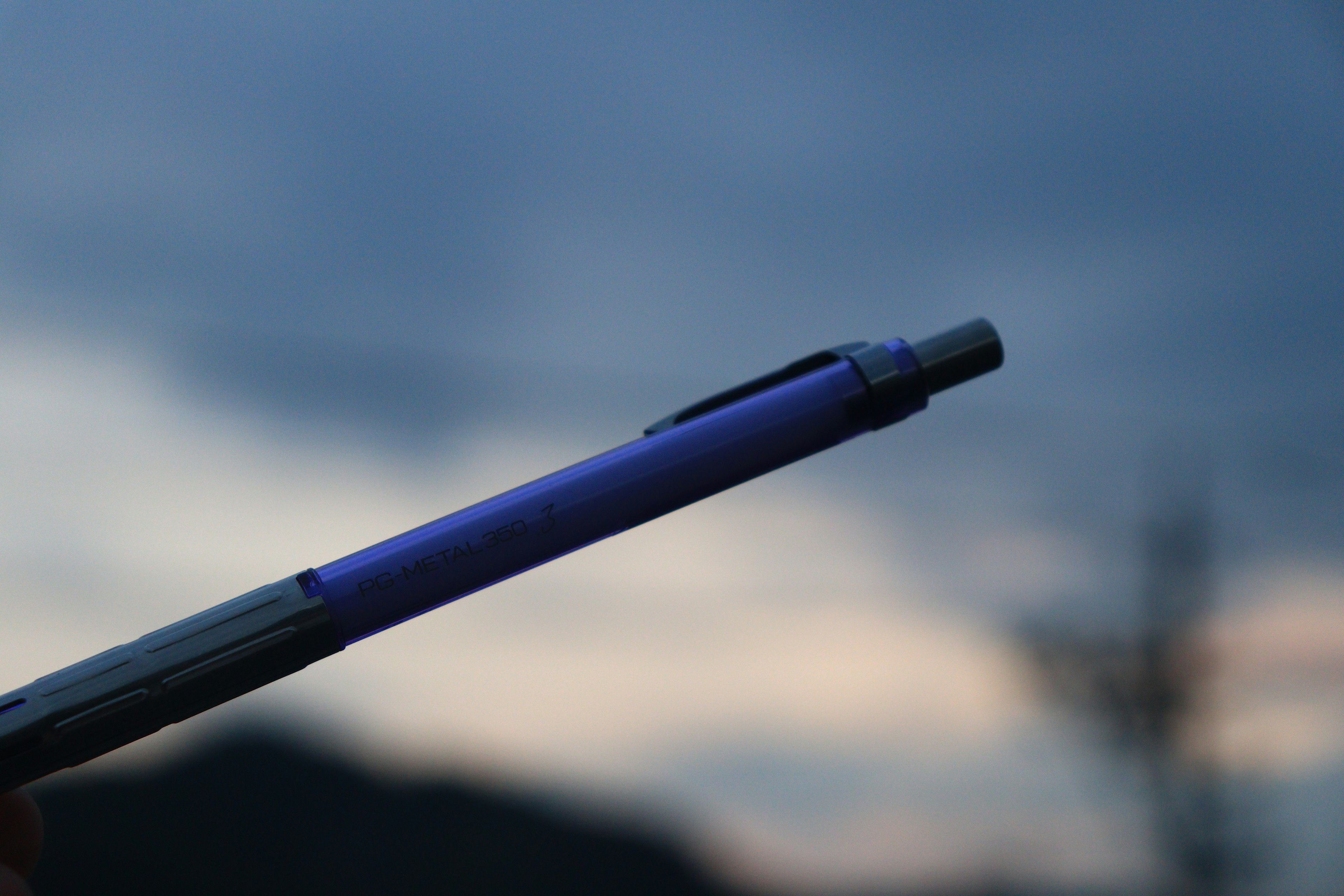 Un bolígrafo azul-púrpura frente a un cielo al atardecer