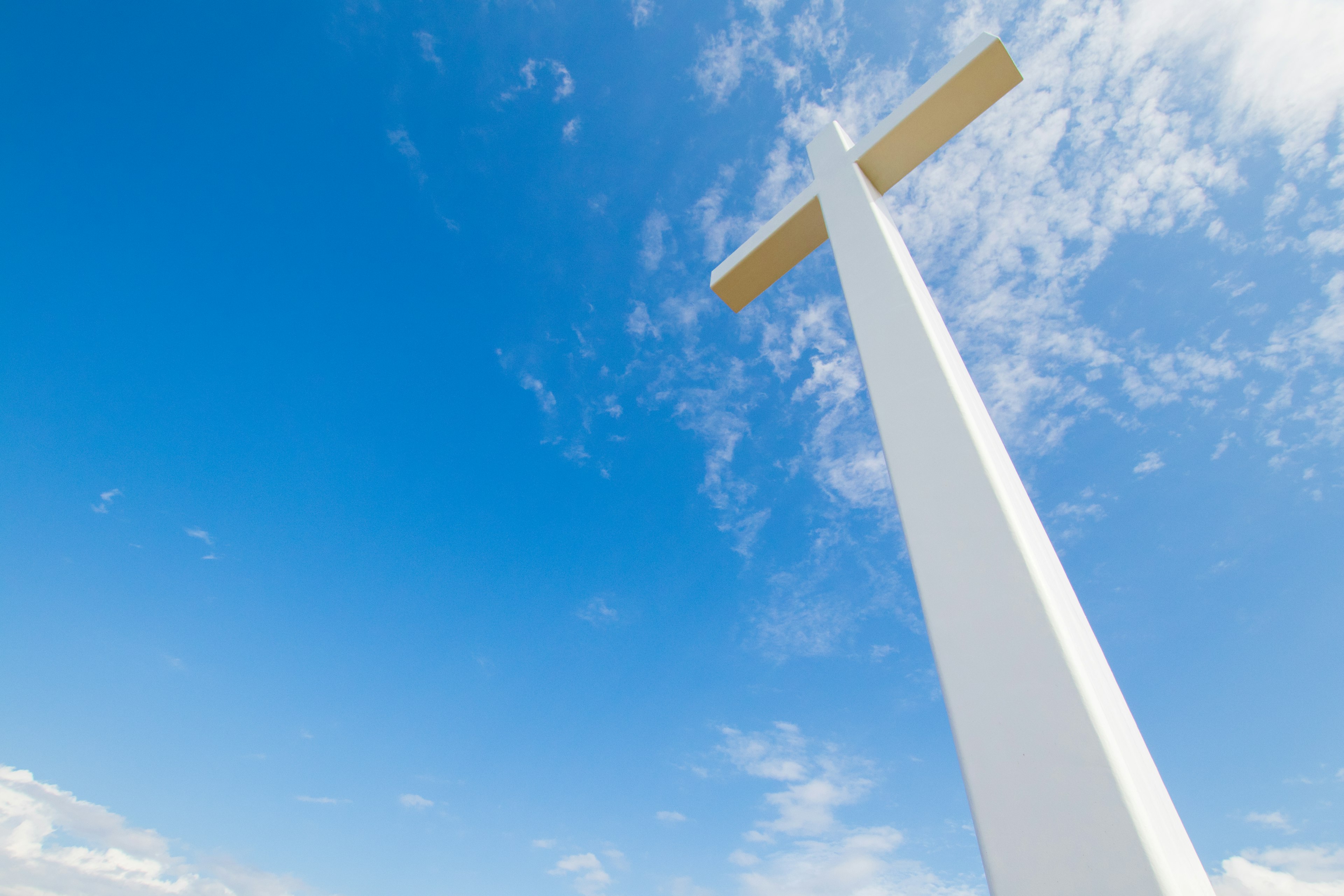 Une grande croix blanche se dresse sous un ciel bleu