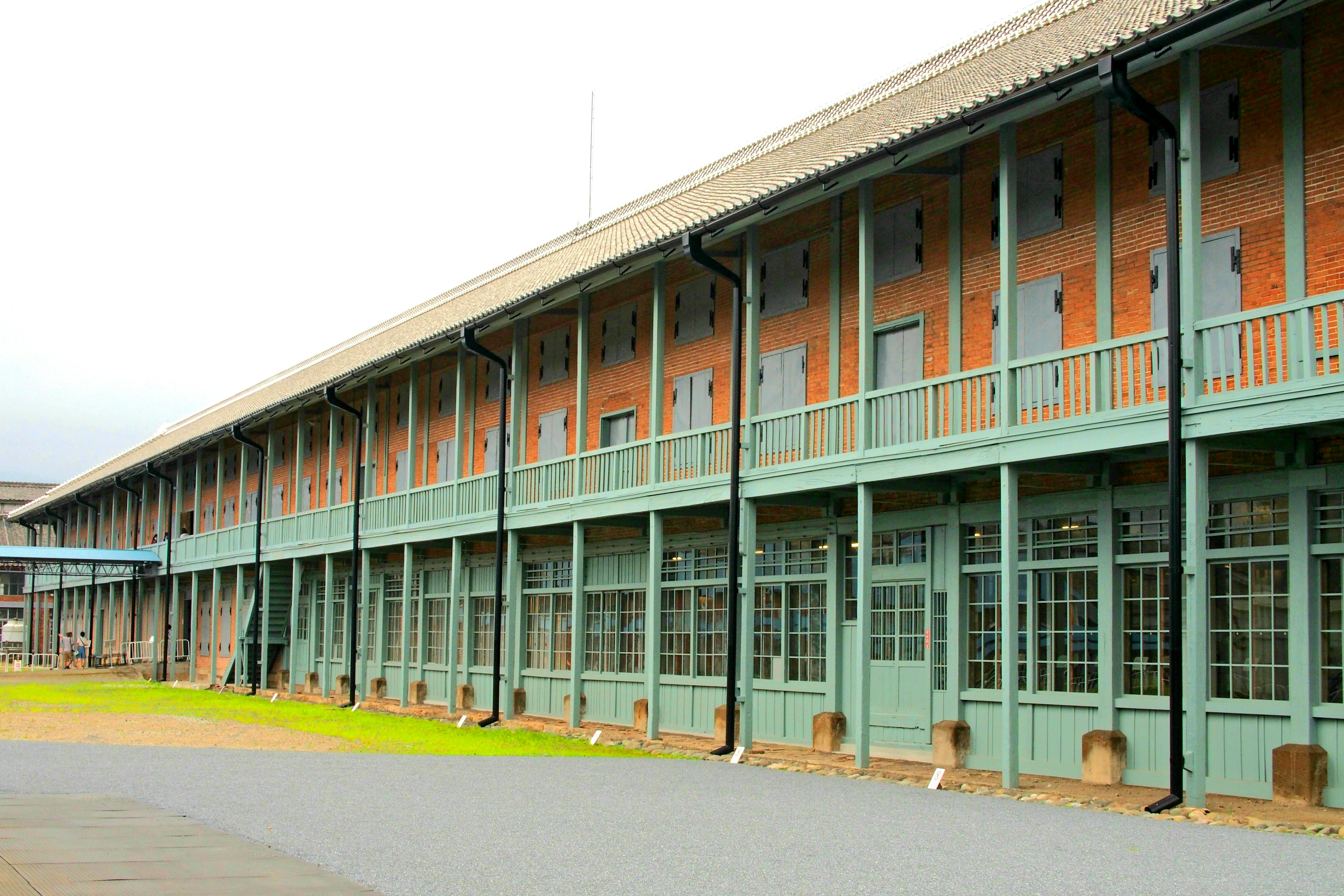 Side view of a brick building with green balconies