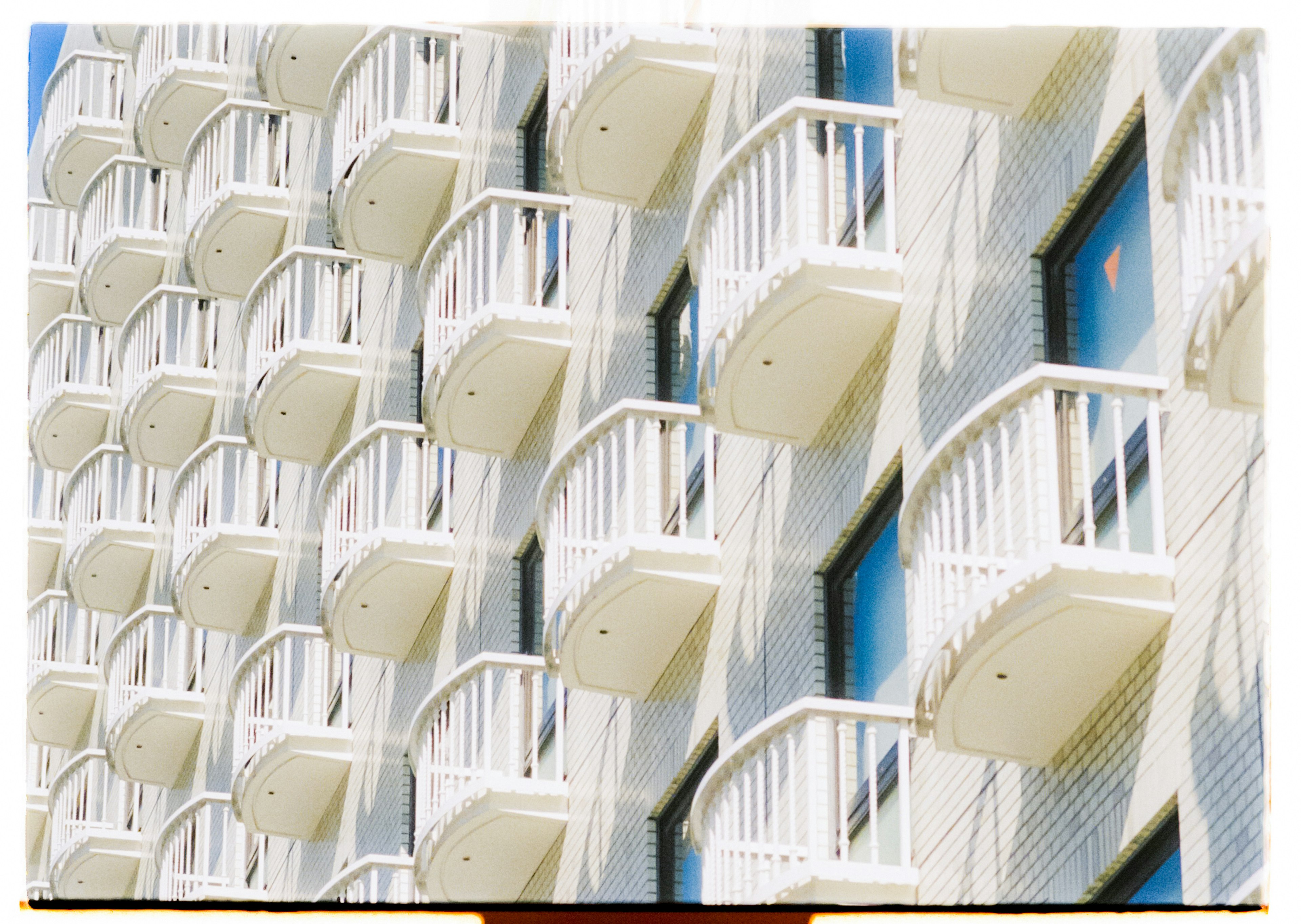 Building facade featuring rows of white balconies