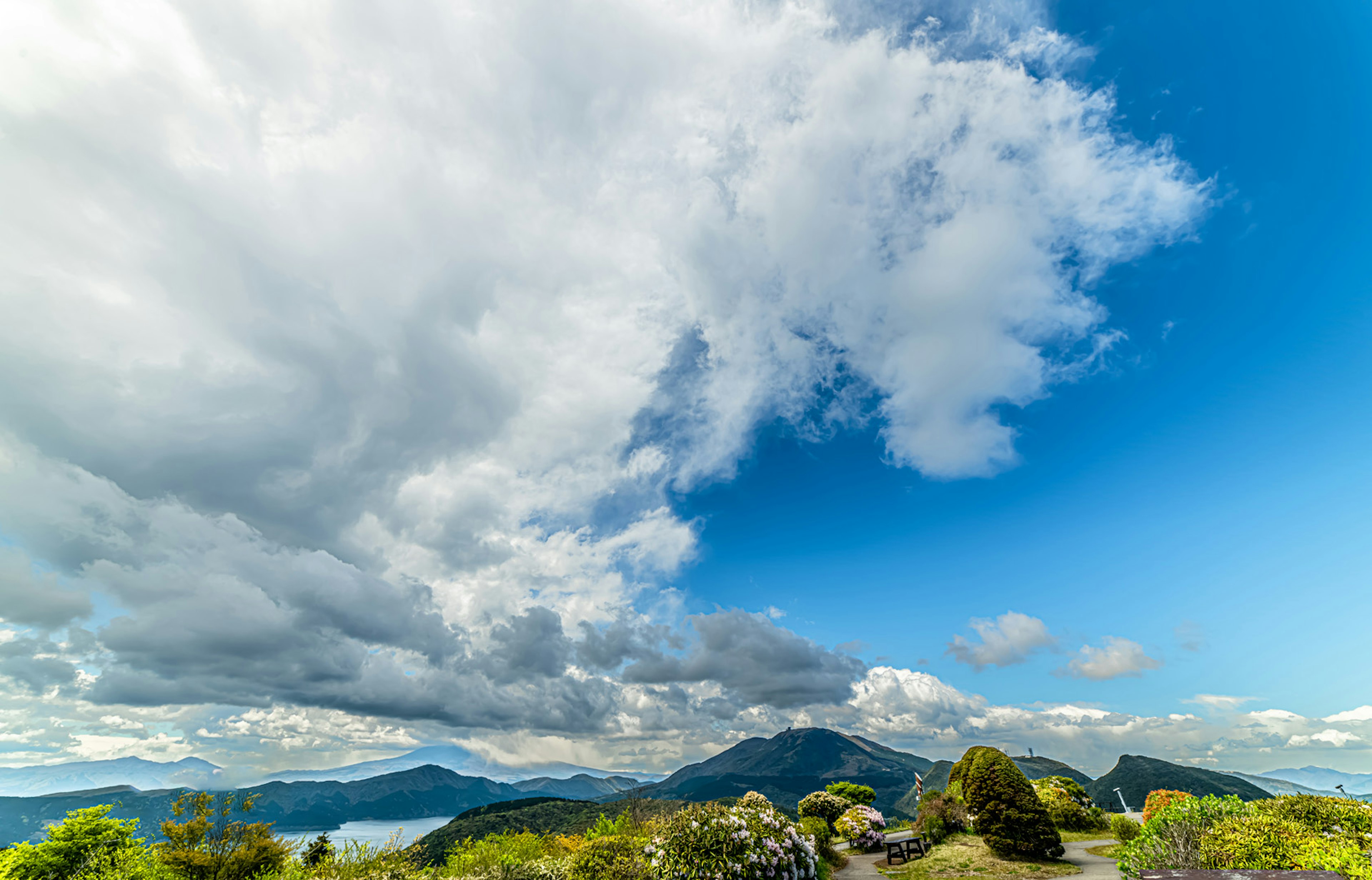 Pemandangan gunung di bawah langit biru dengan awan