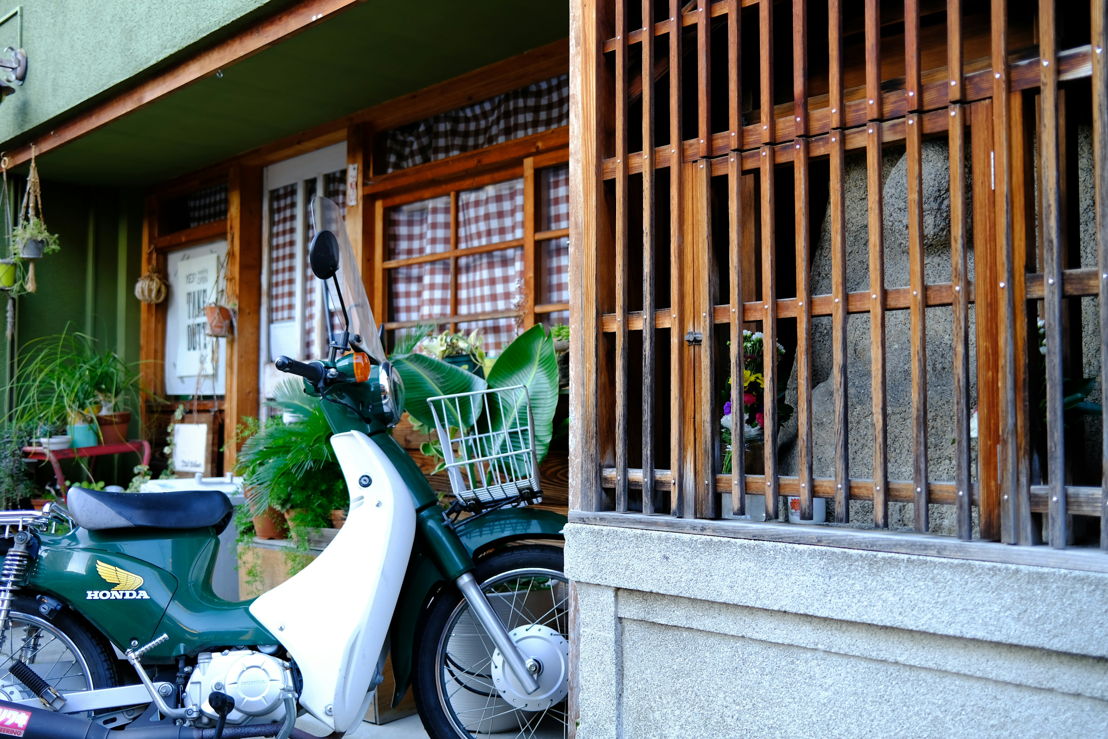 緑のバイクと竹のフェンスがある伝統的な日本の家