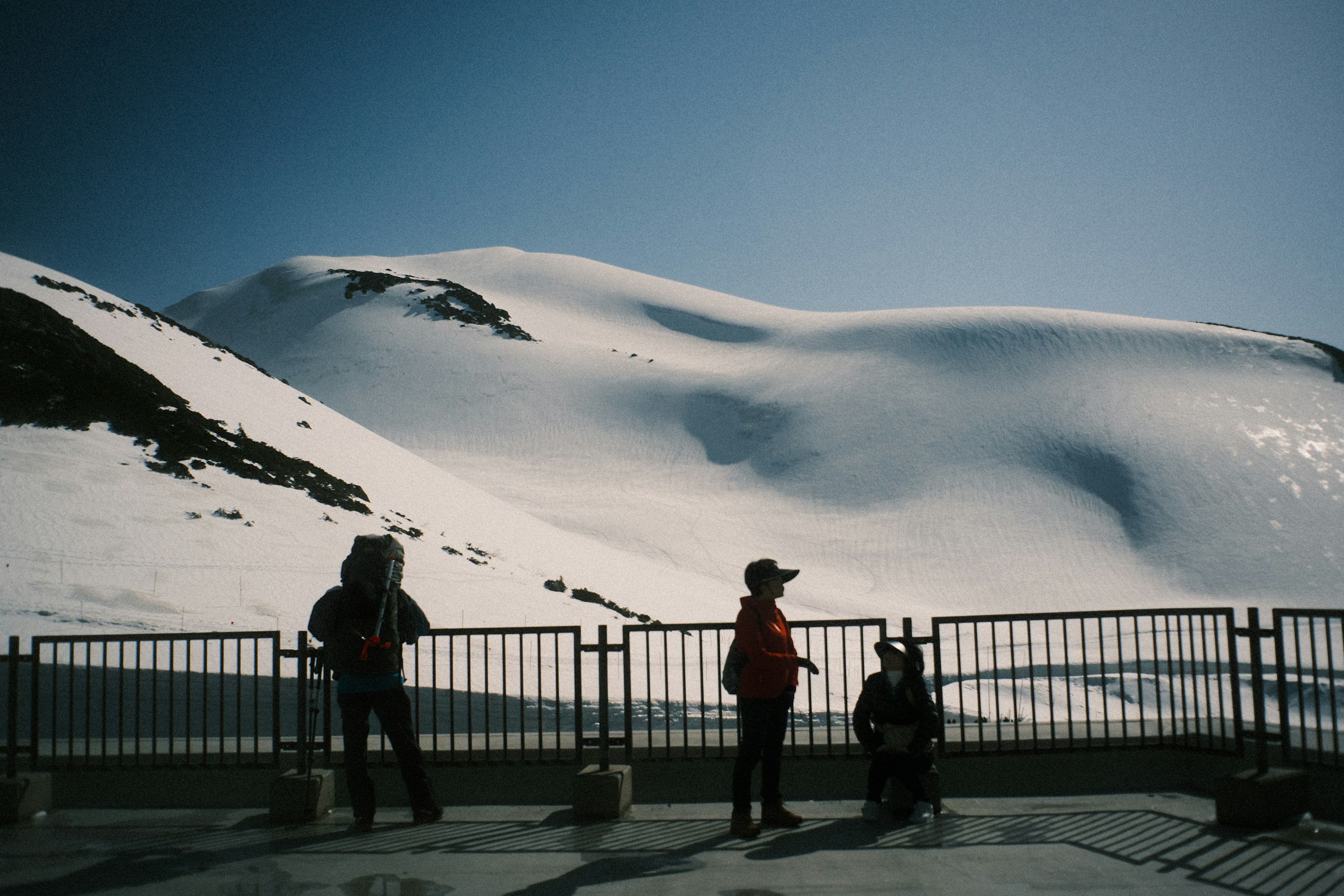 Montaña nevada con siluetas de turistas