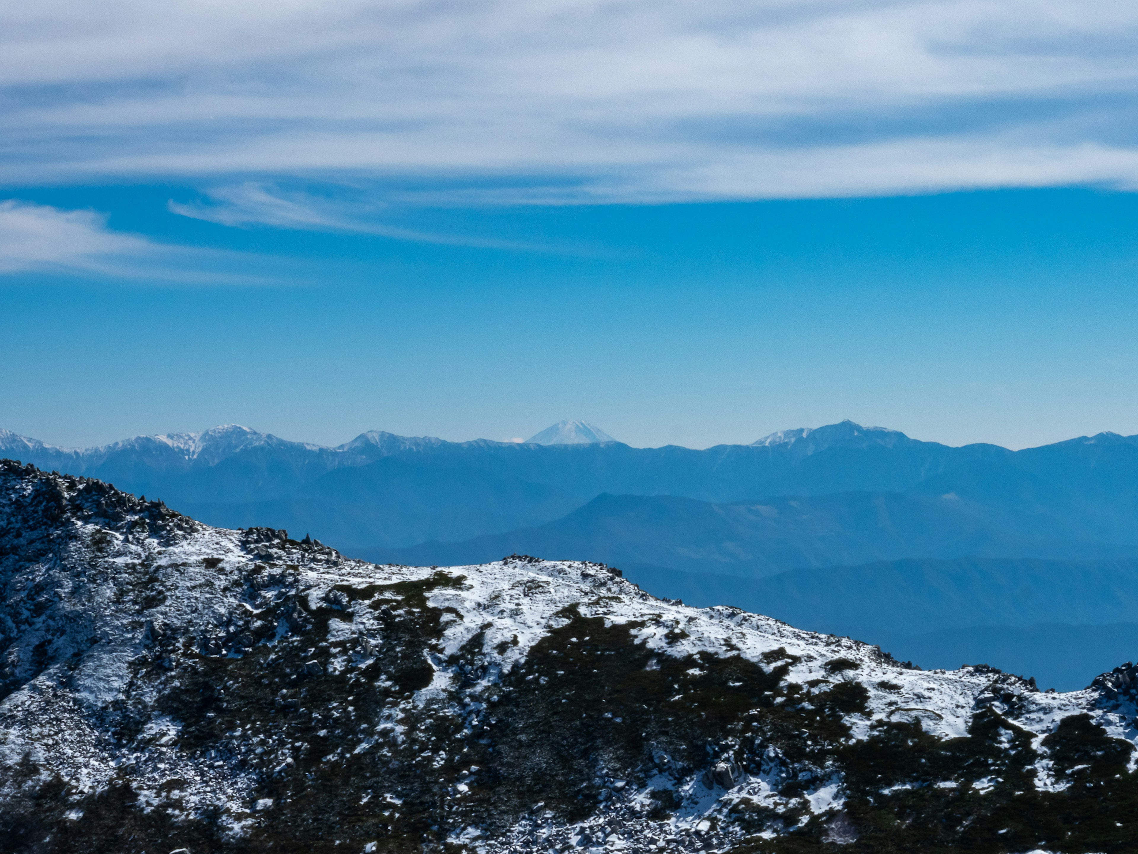 Montagne innevate sotto un cielo blu chiaro