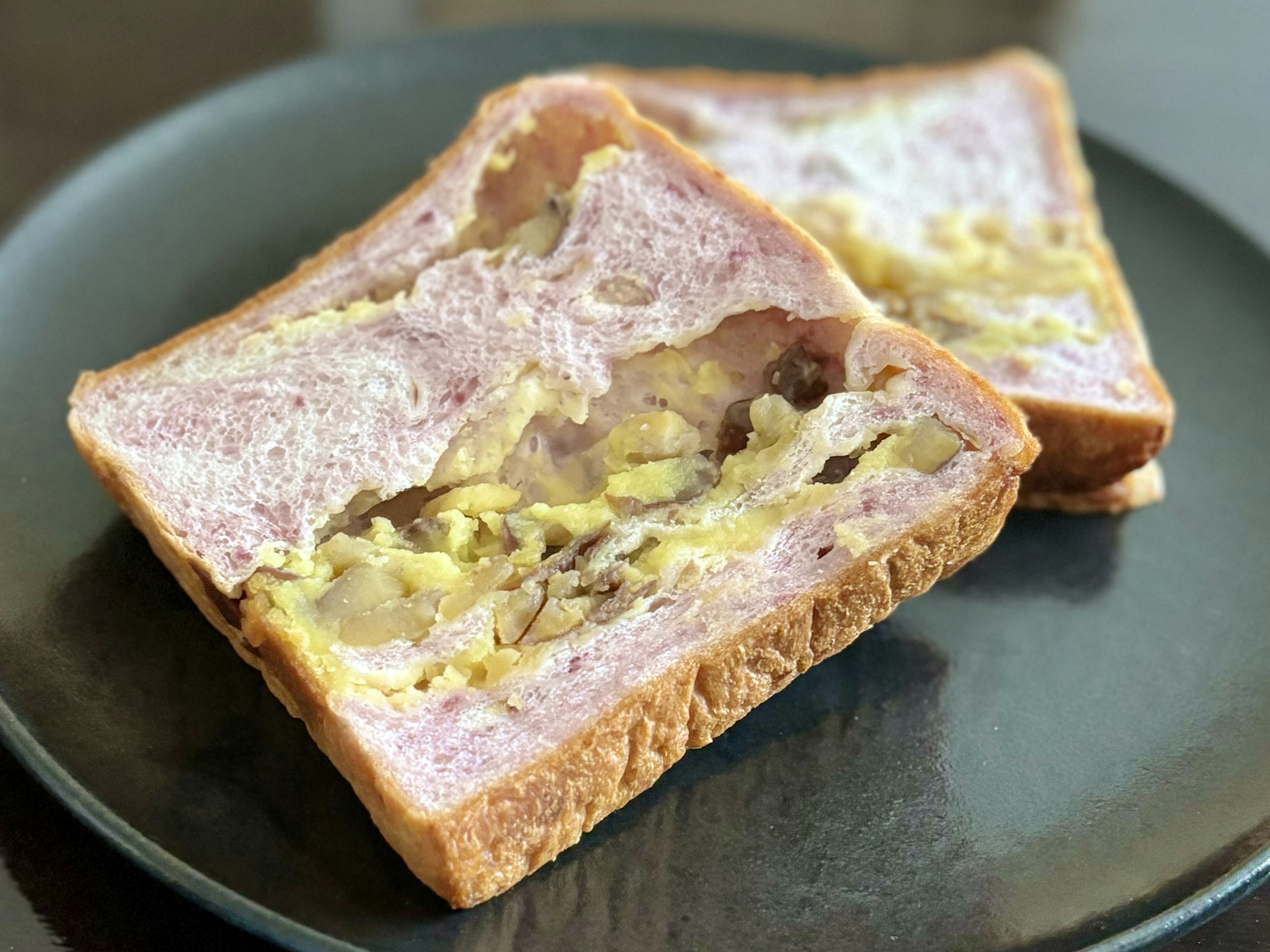 Sandwich with visible filling wrapped in purple bread