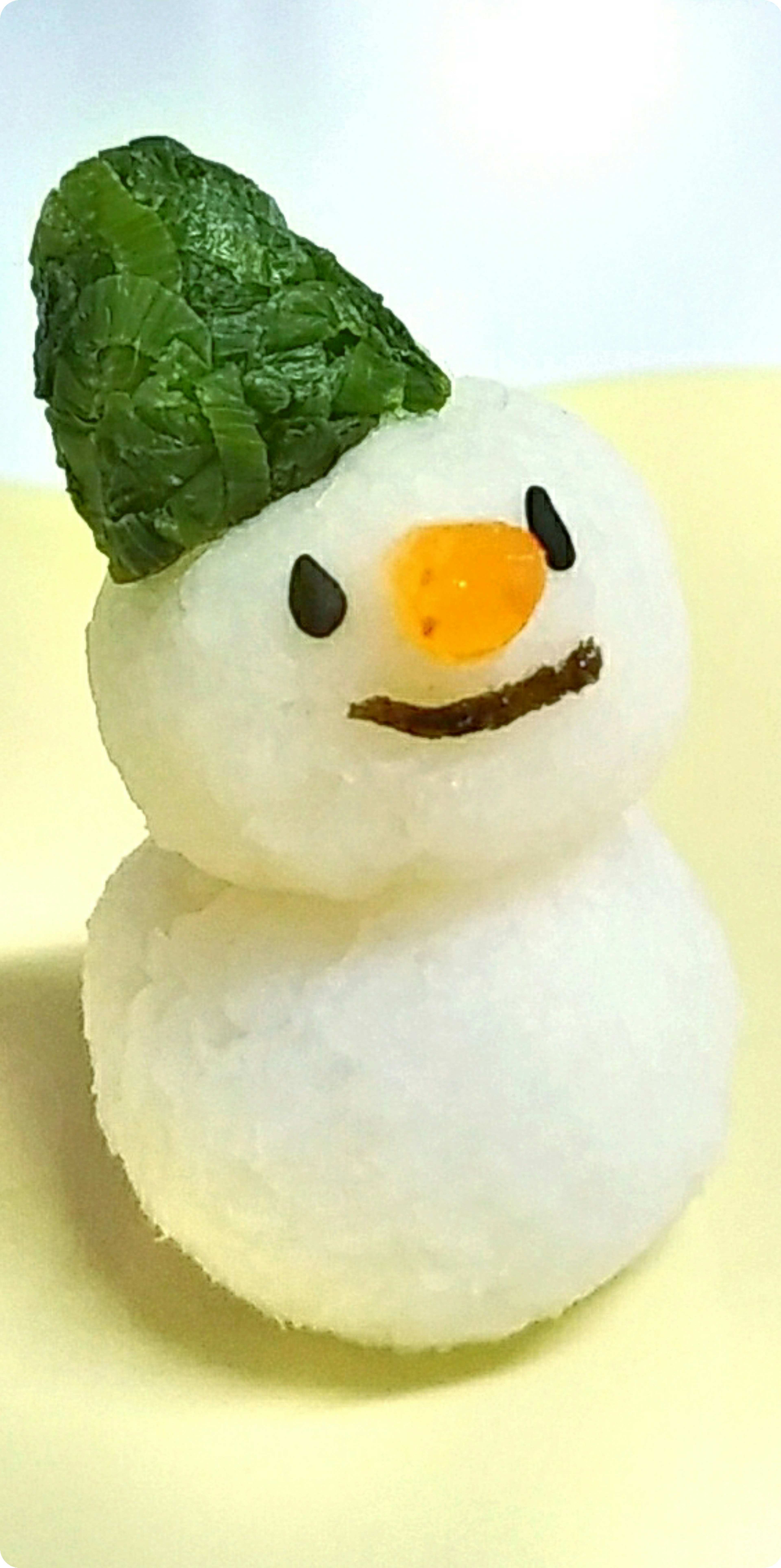 かわいい雪だるまの形をしたおにぎりに、緑の葉っぱの帽子とオレンジの鼻