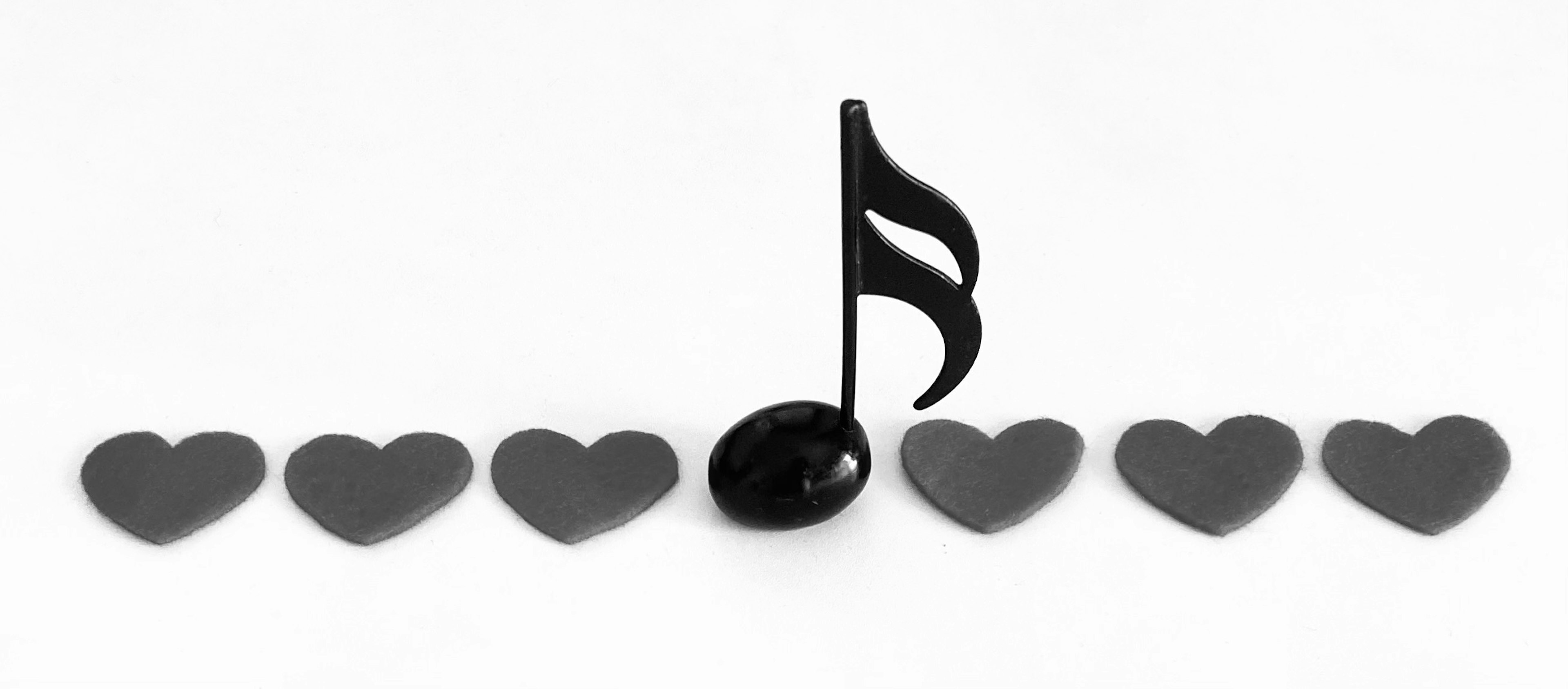 A black music note with a series of black hearts arranged in a line