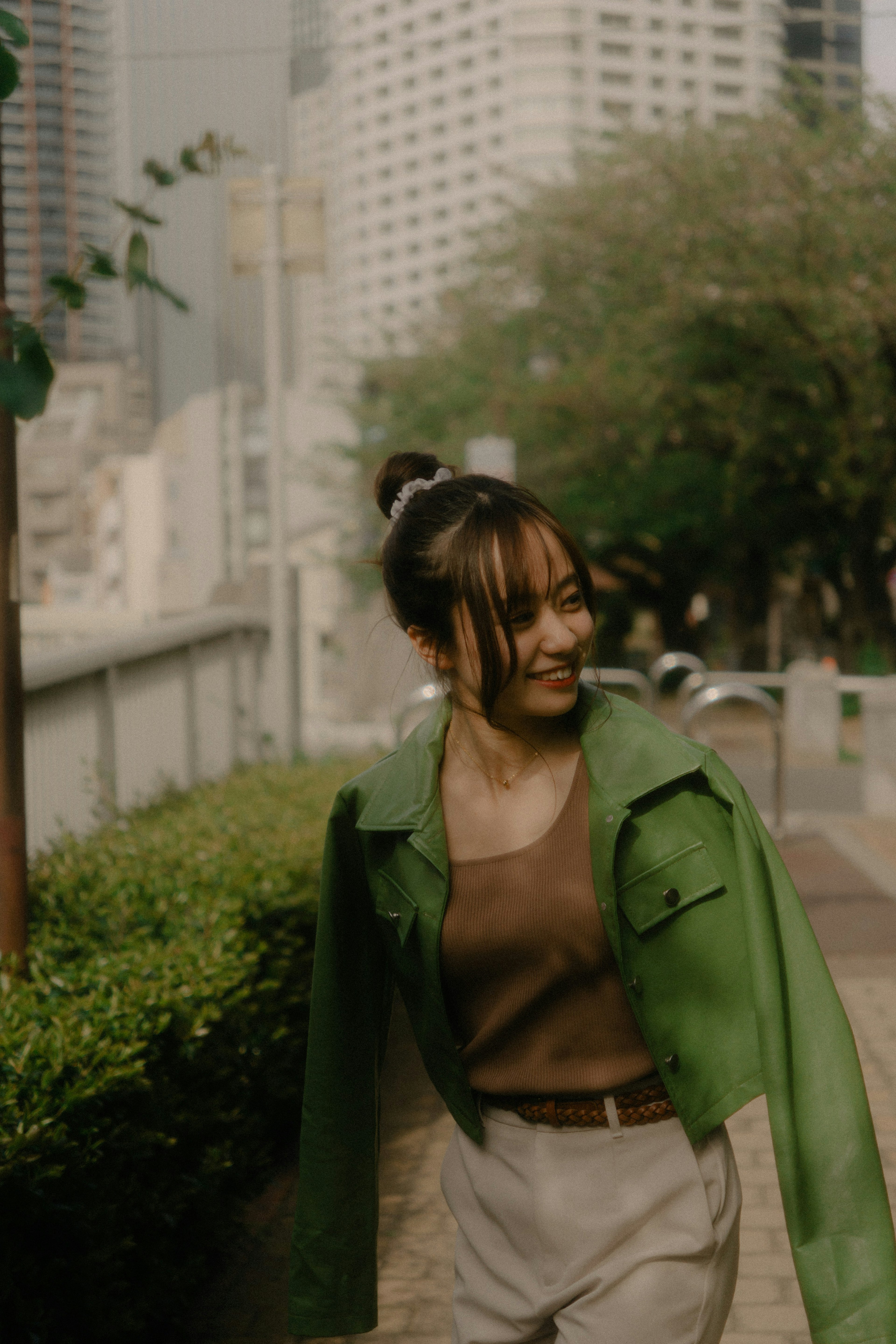 Woman wearing a green jacket in an urban setting