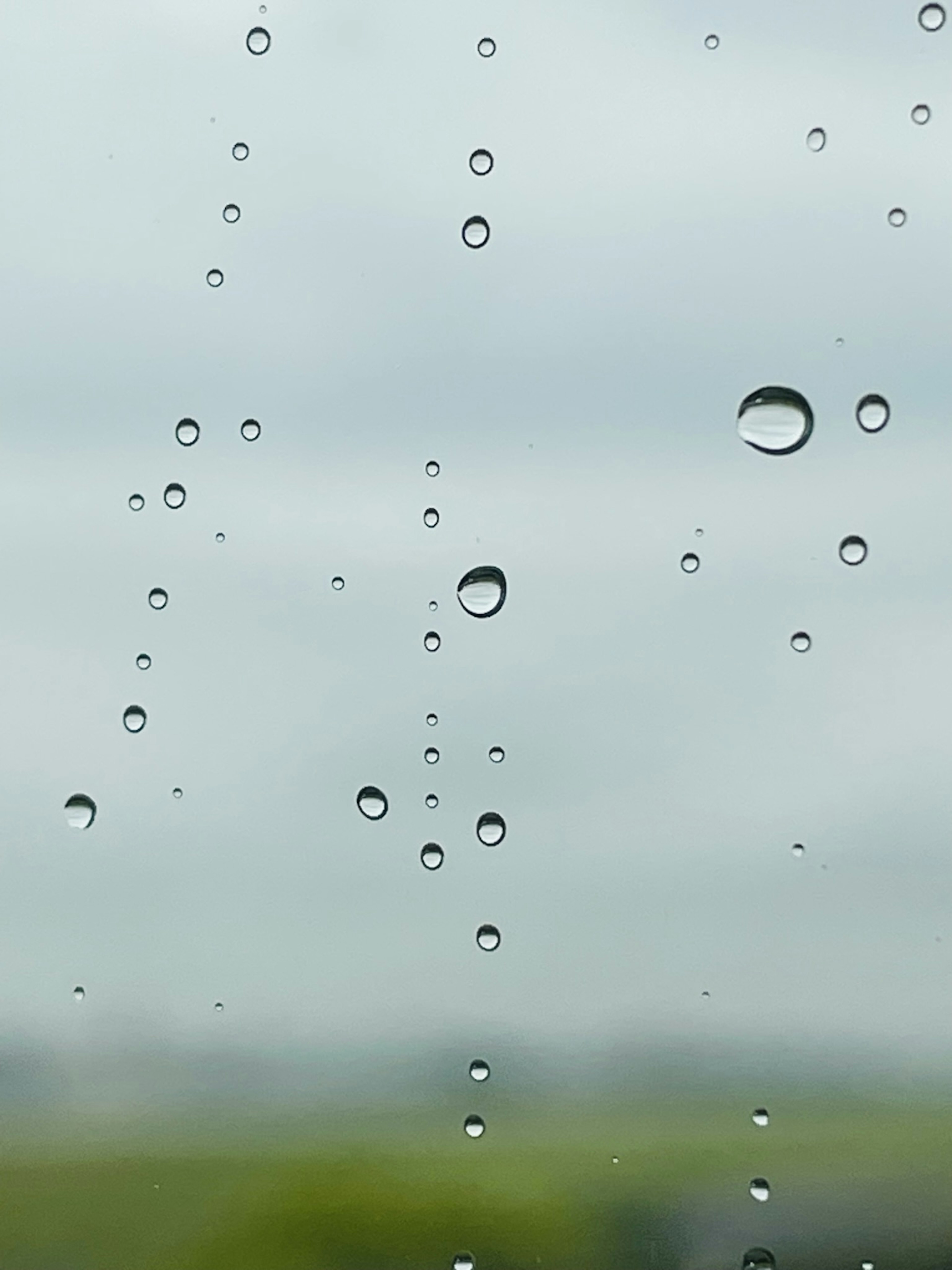 Close-up of raindrops on a window with a blurred background