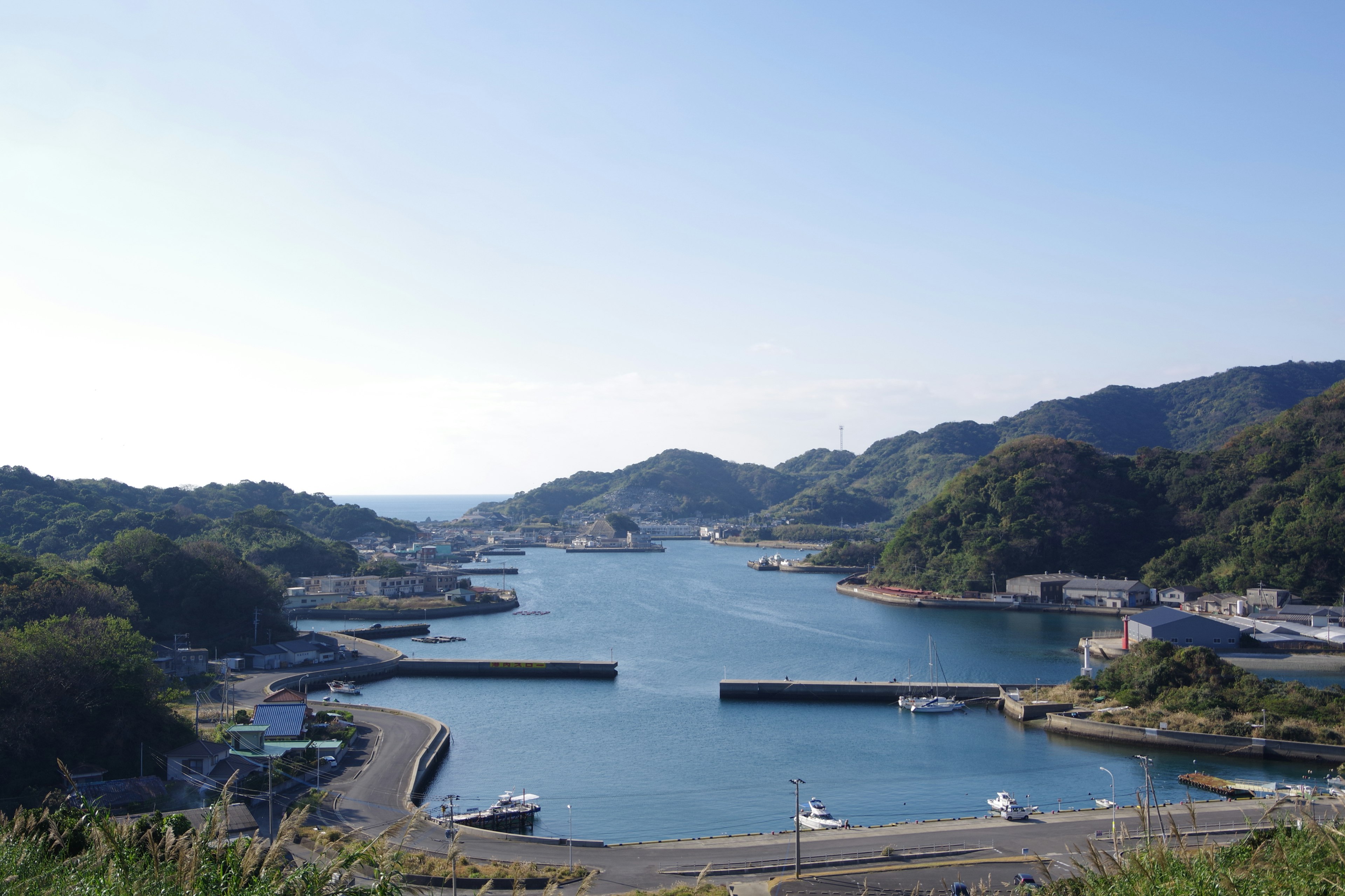 Vue pittoresque d'un port tranquille avec des eaux bleues et des collines environnantes