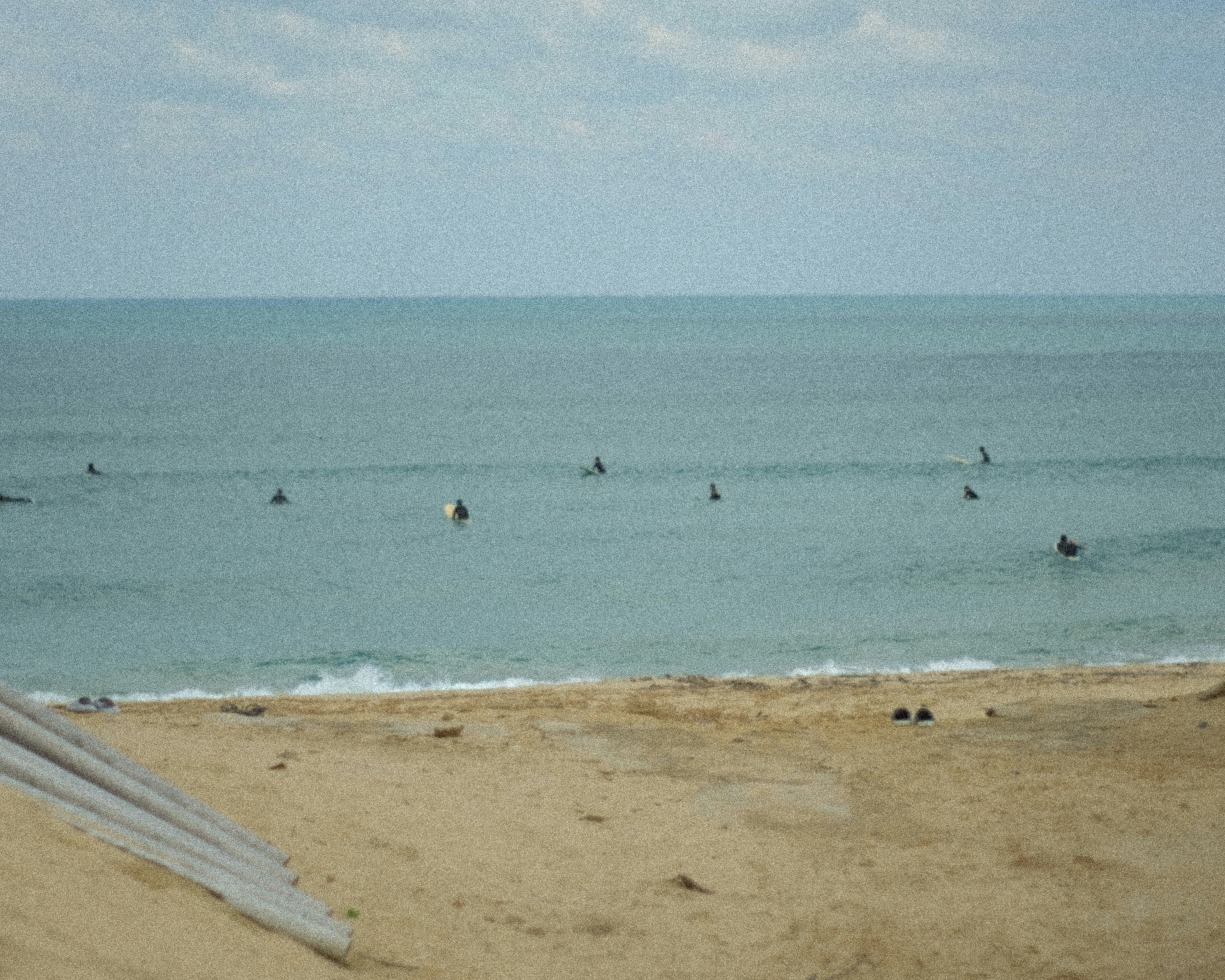 Beach scene with surfers riding waves in the ocean