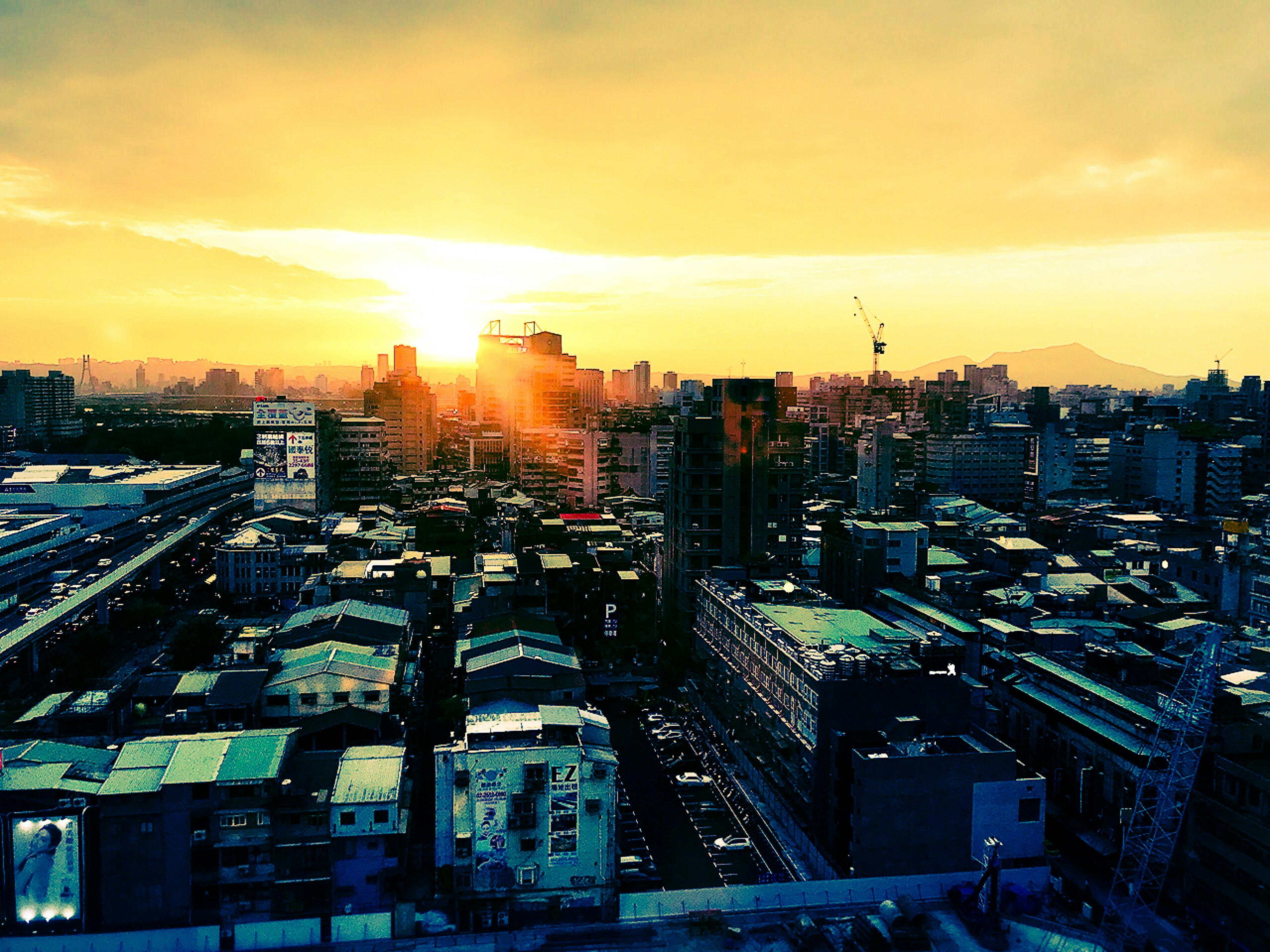 Cityscape at sunset with high-rise buildings and houses