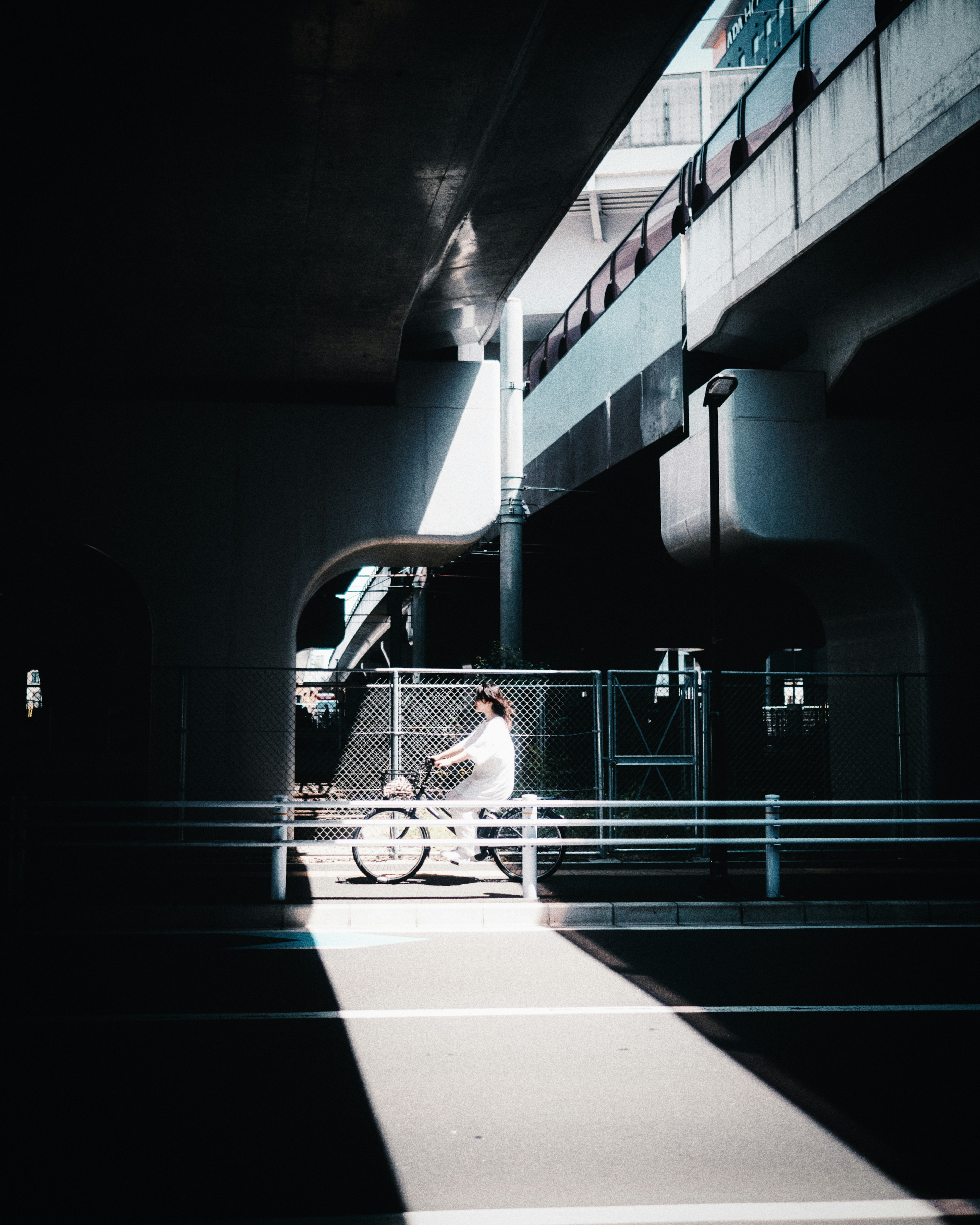 A person riding a bicycle through a dark tunnel with light beams