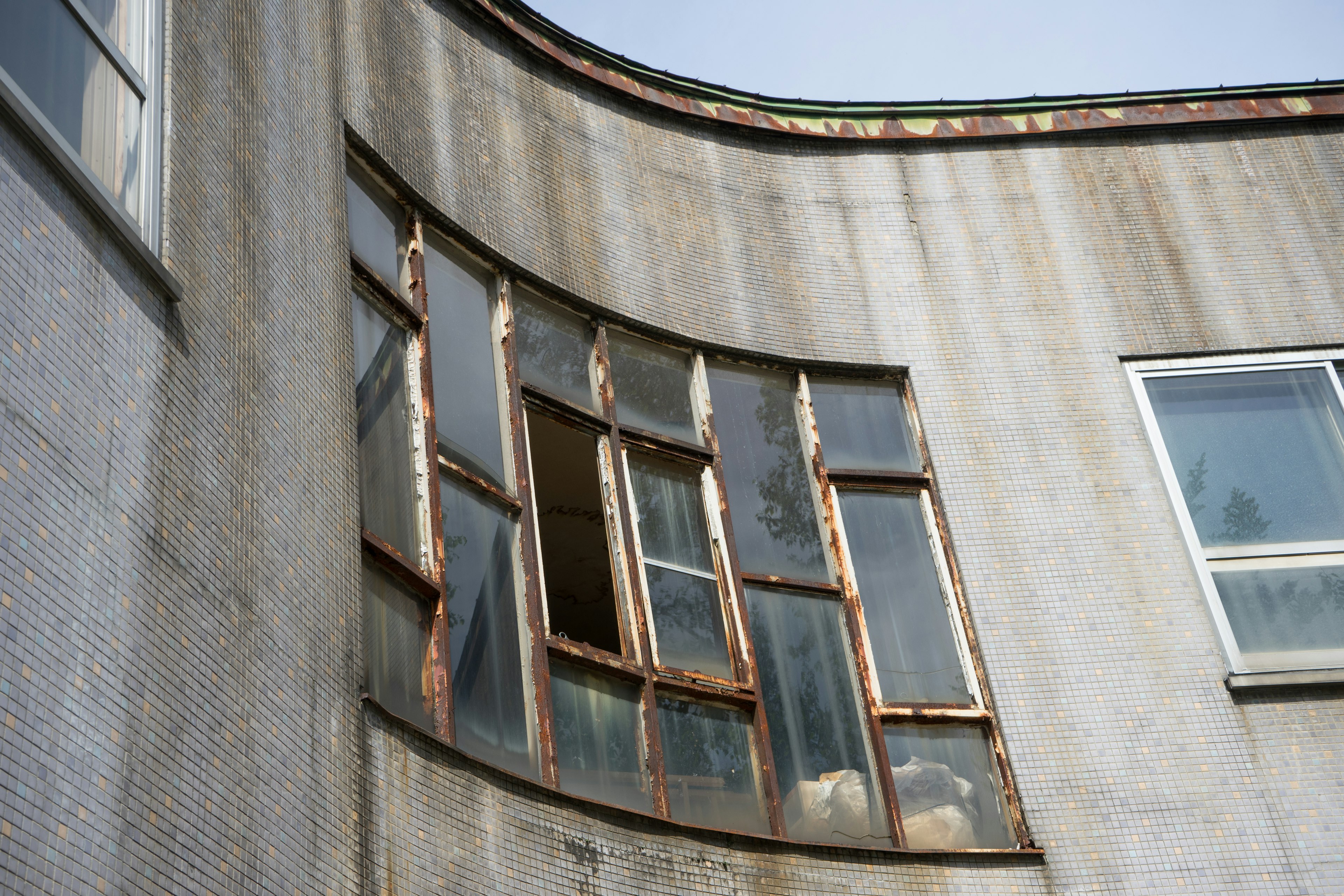 Krumme Wand mit alten Fenstern und verwitterter Fassade