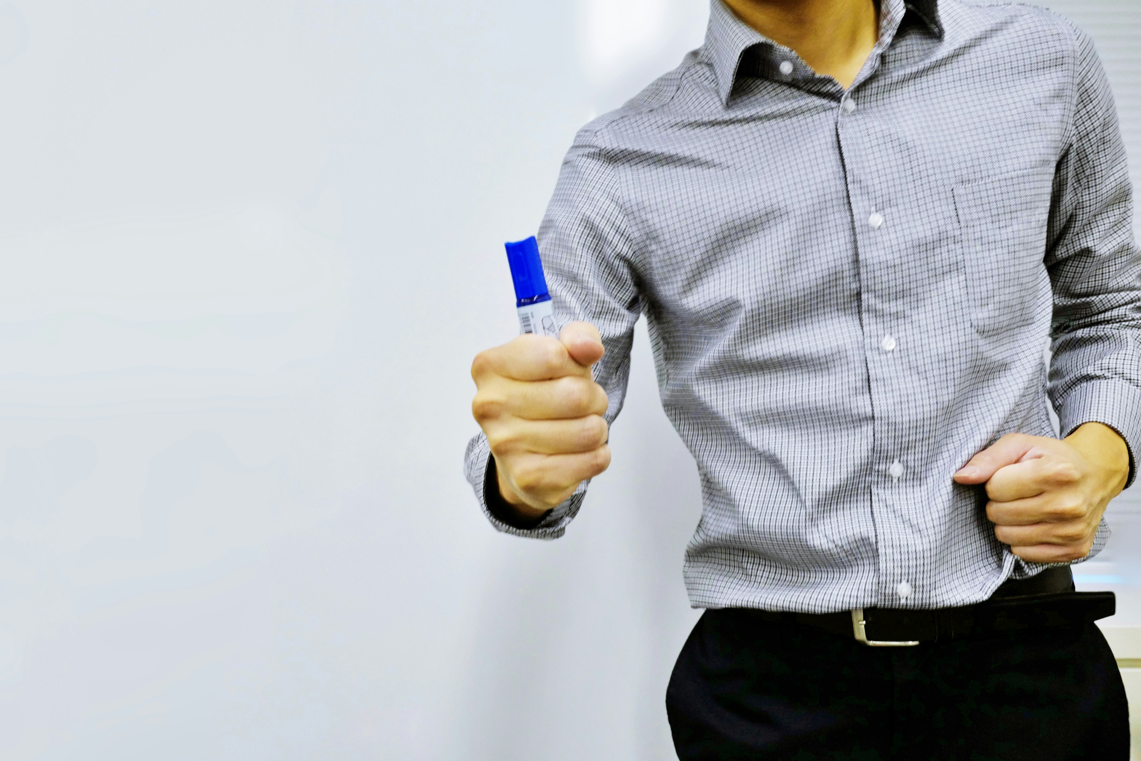 A man in a gray shirt holding a blue marker