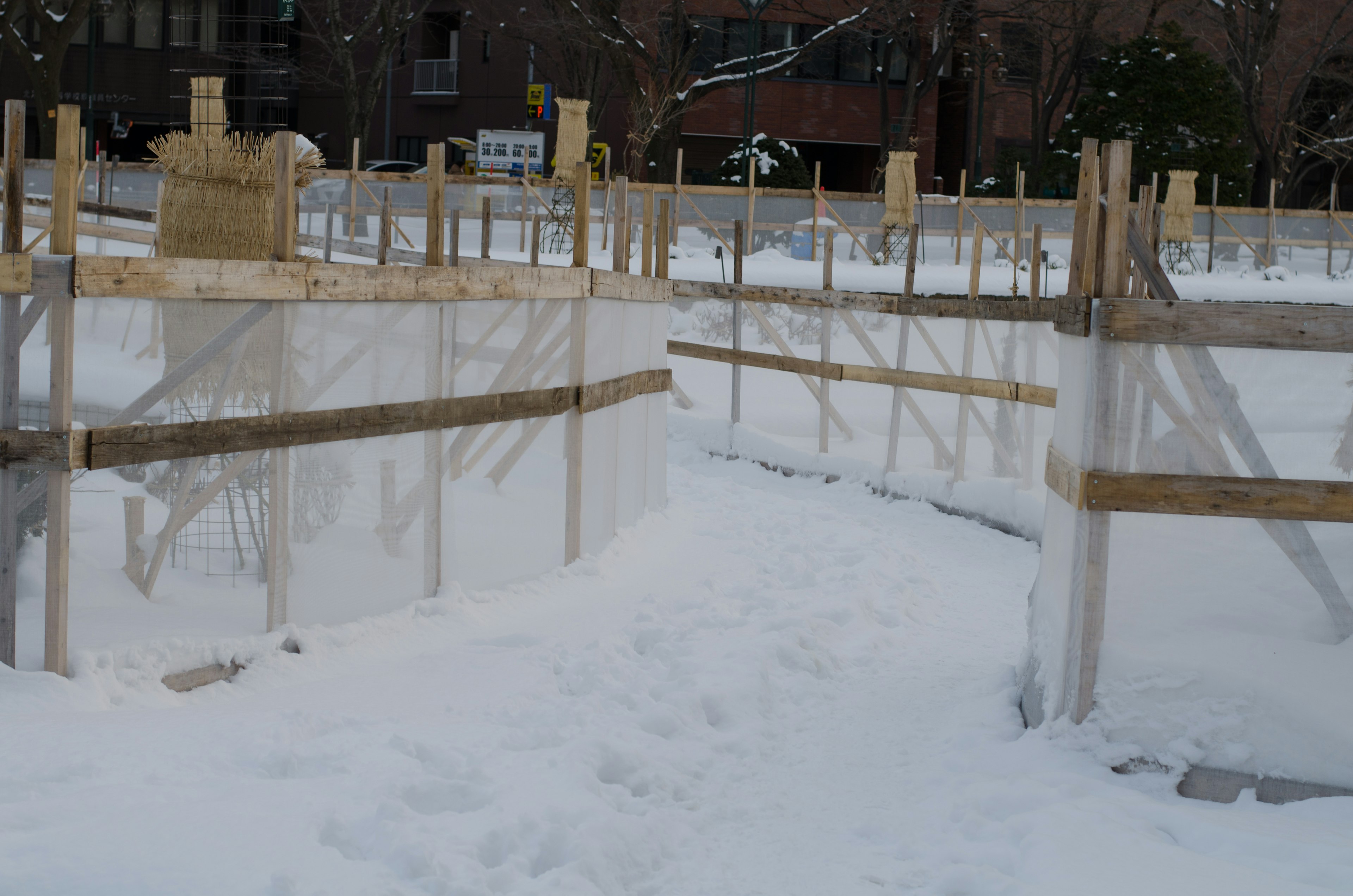 Un'area innevata con muri trasparenti e strutture in legno