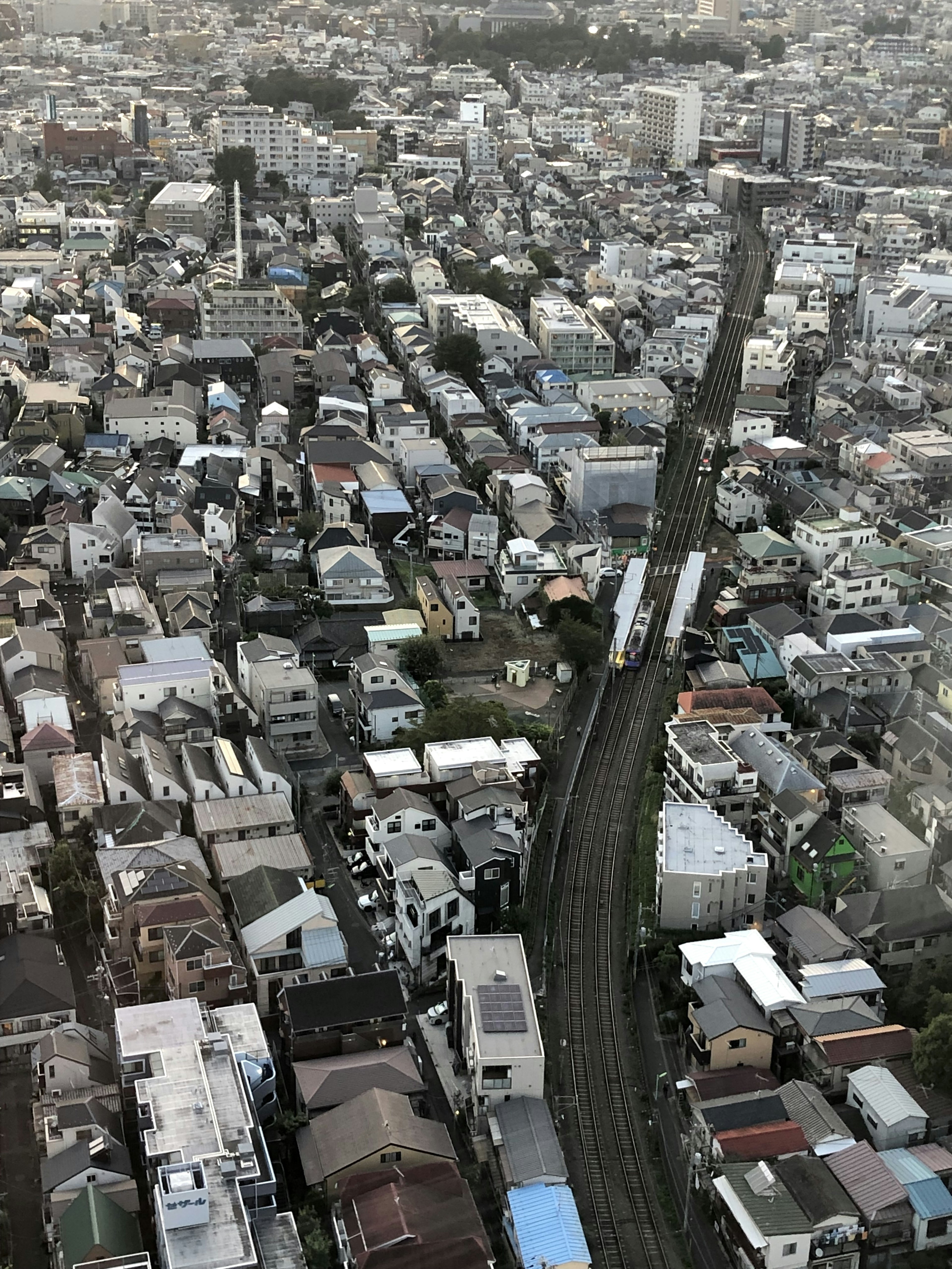 Vue aérienne d'un quartier résidentiel à Tokyo montrant des maisons et une voie ferrée