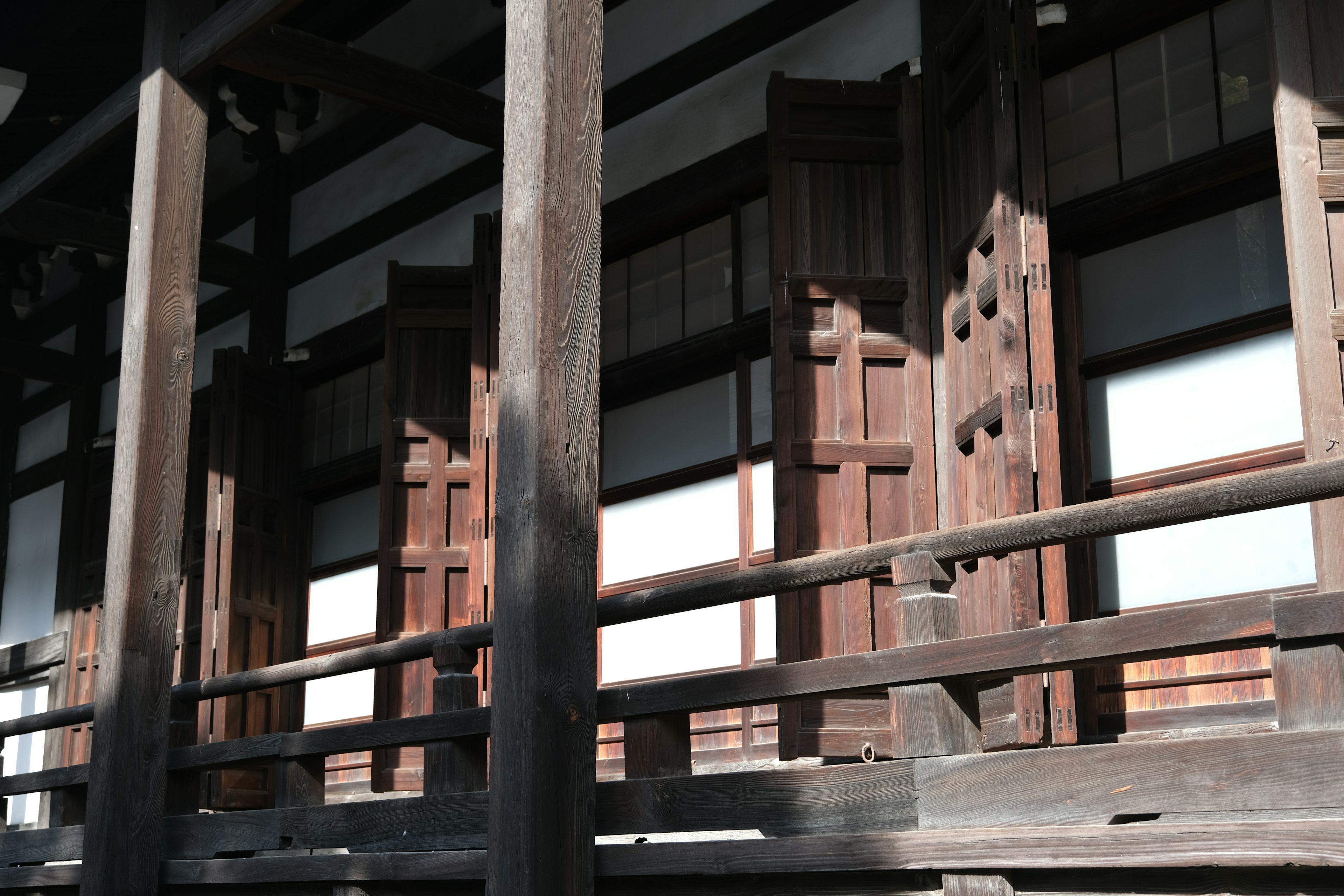 Koridor kayu dengan pintu geser terbuka di bangunan tradisional Jepang