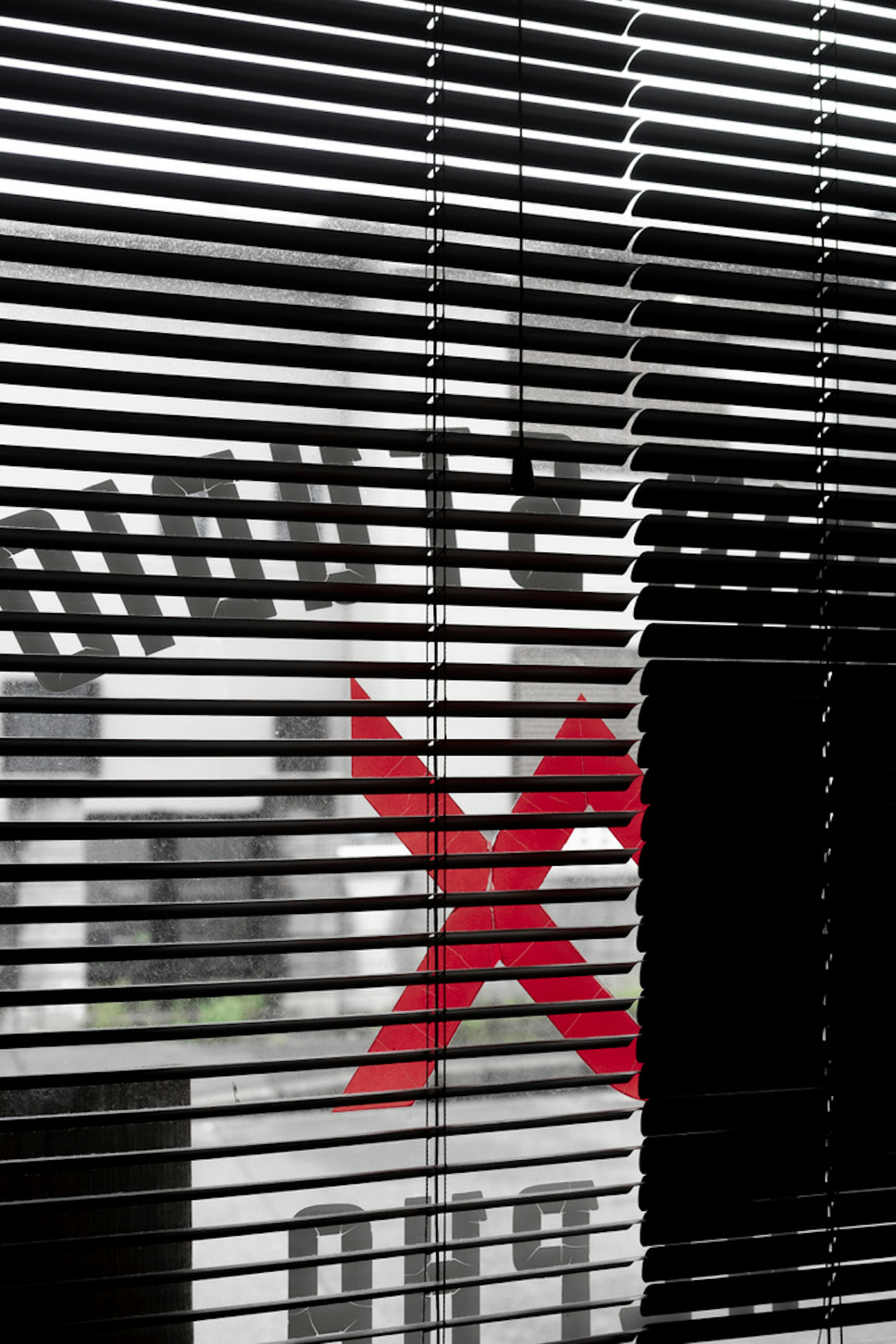 Red X mark and text visible through blinds