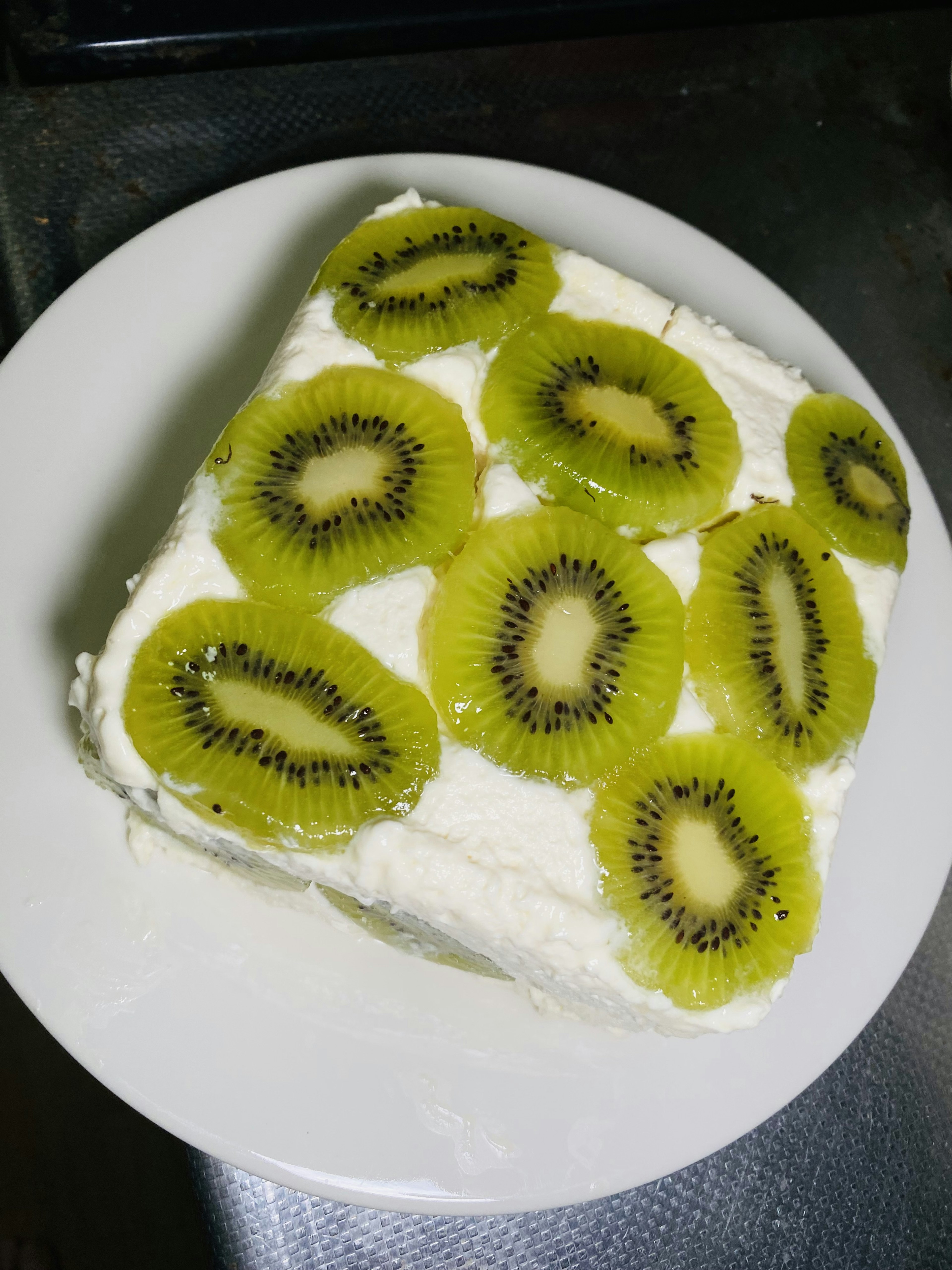 Piring dessert dengan krim dan irisan kiwi