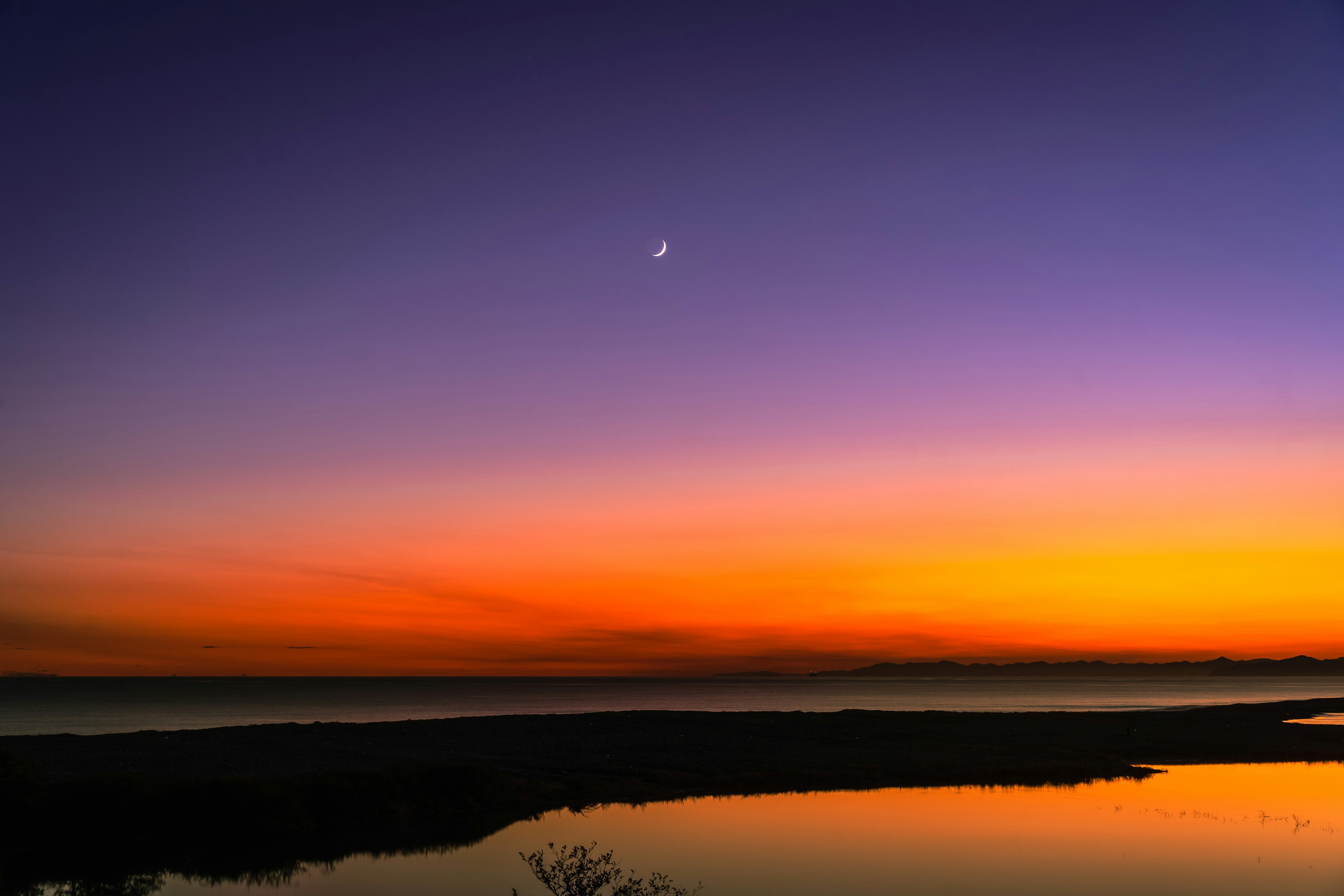 美しい夕焼けの空に月が輝く風景