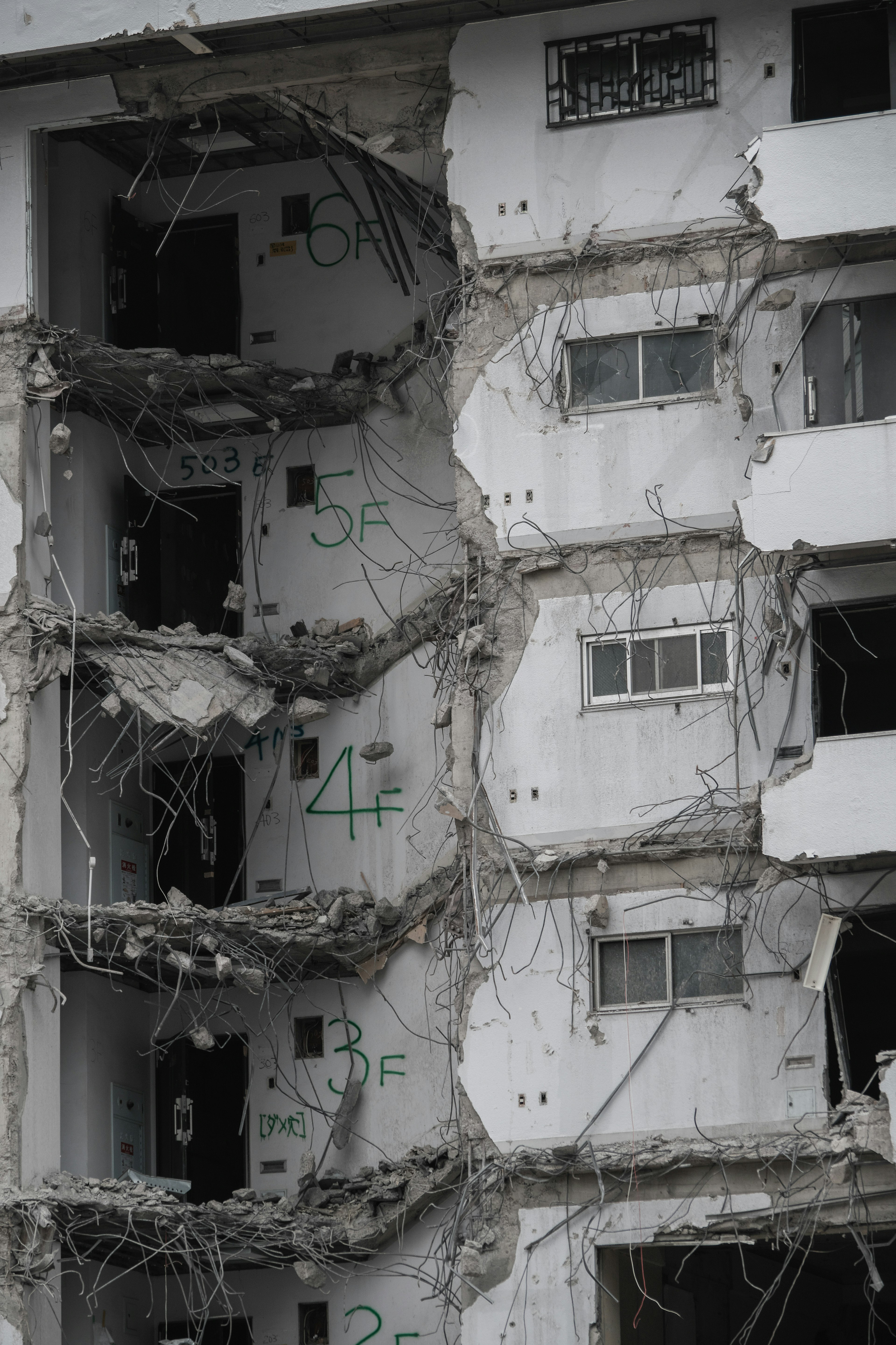 Facade of a demolished building with exposed walls and debris